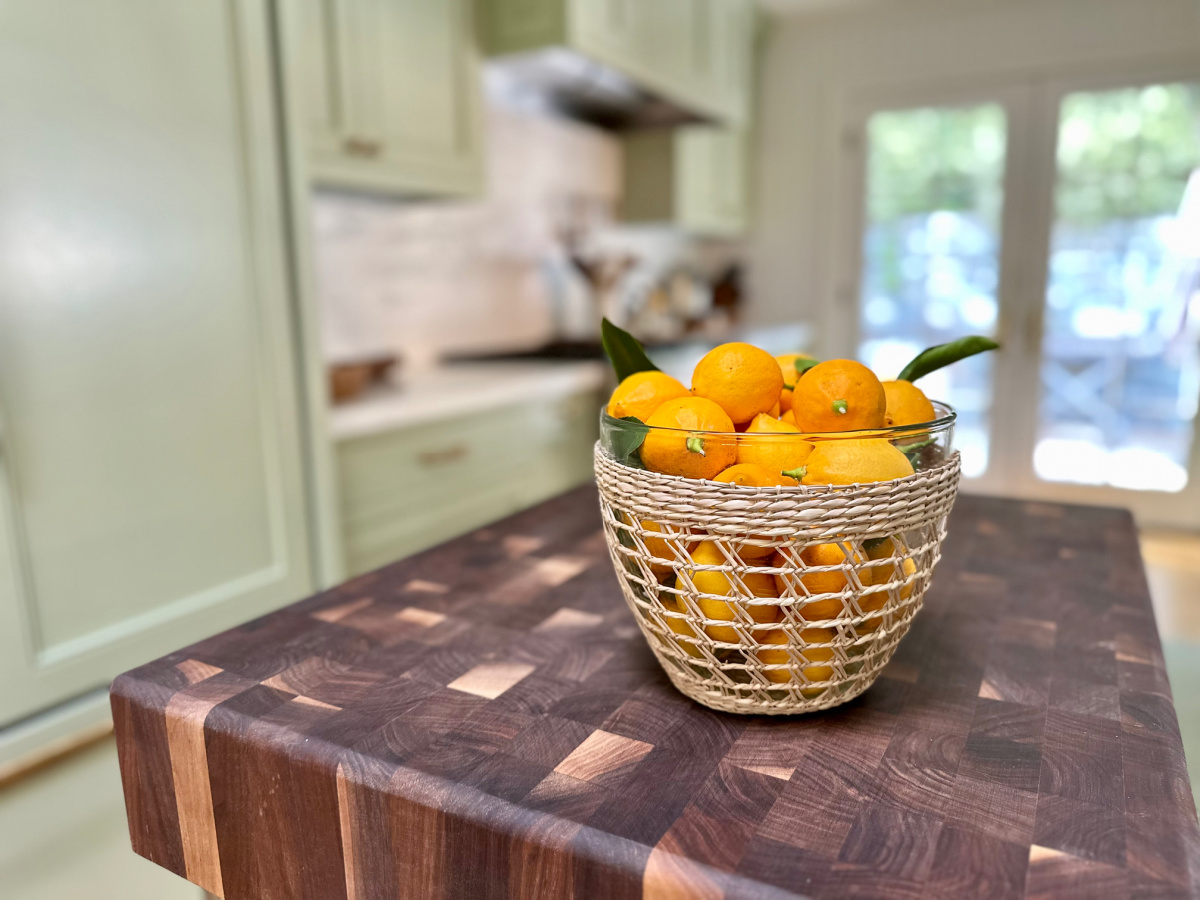 Woven bowl full of lemons on kitchen island.