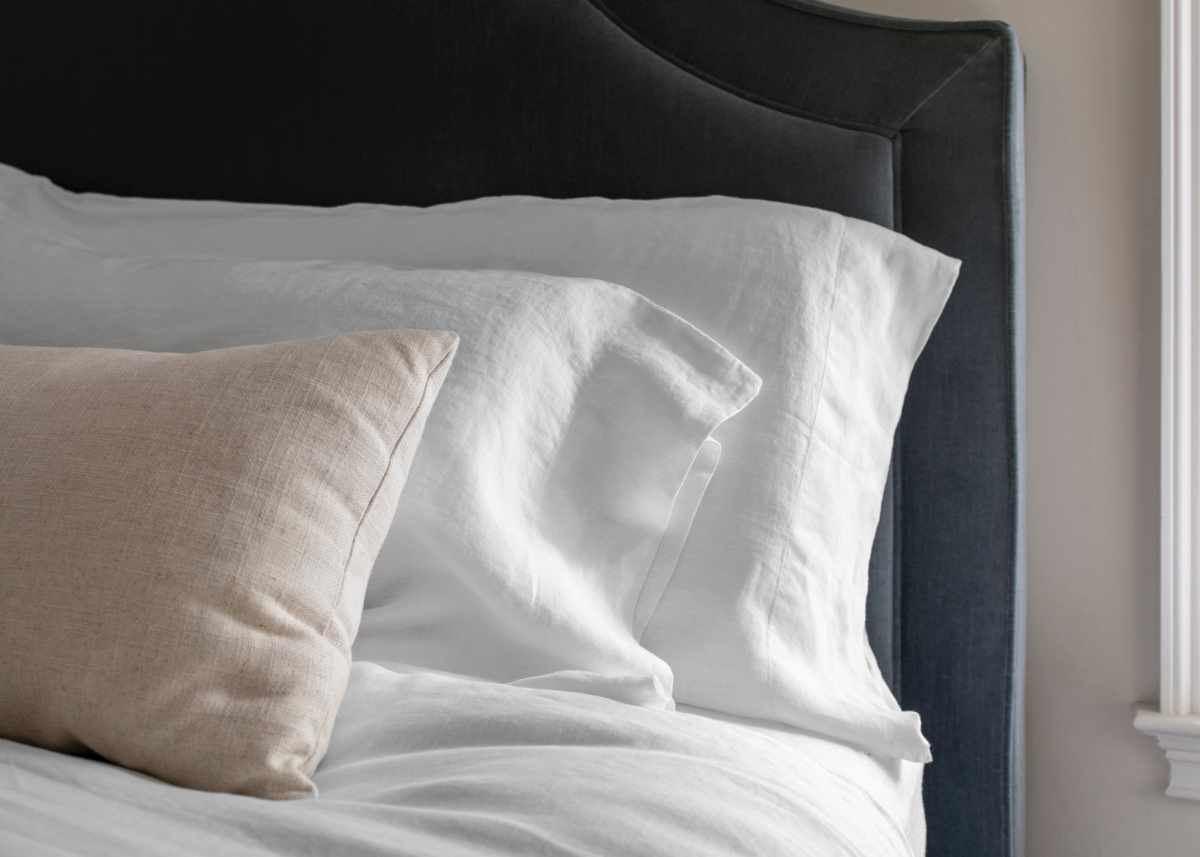 Quince sheets and pillow cases against blue velvet headboard.