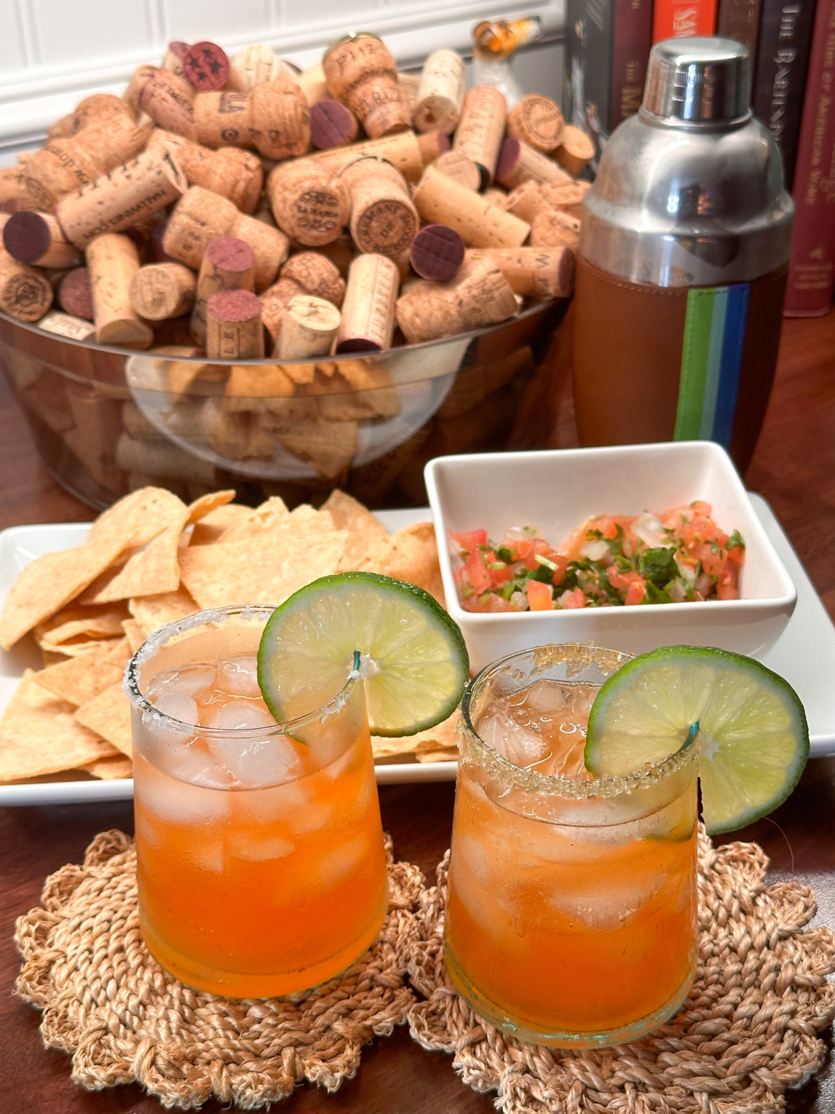 Aperol Magaritas next to platter of chips and salsa.
