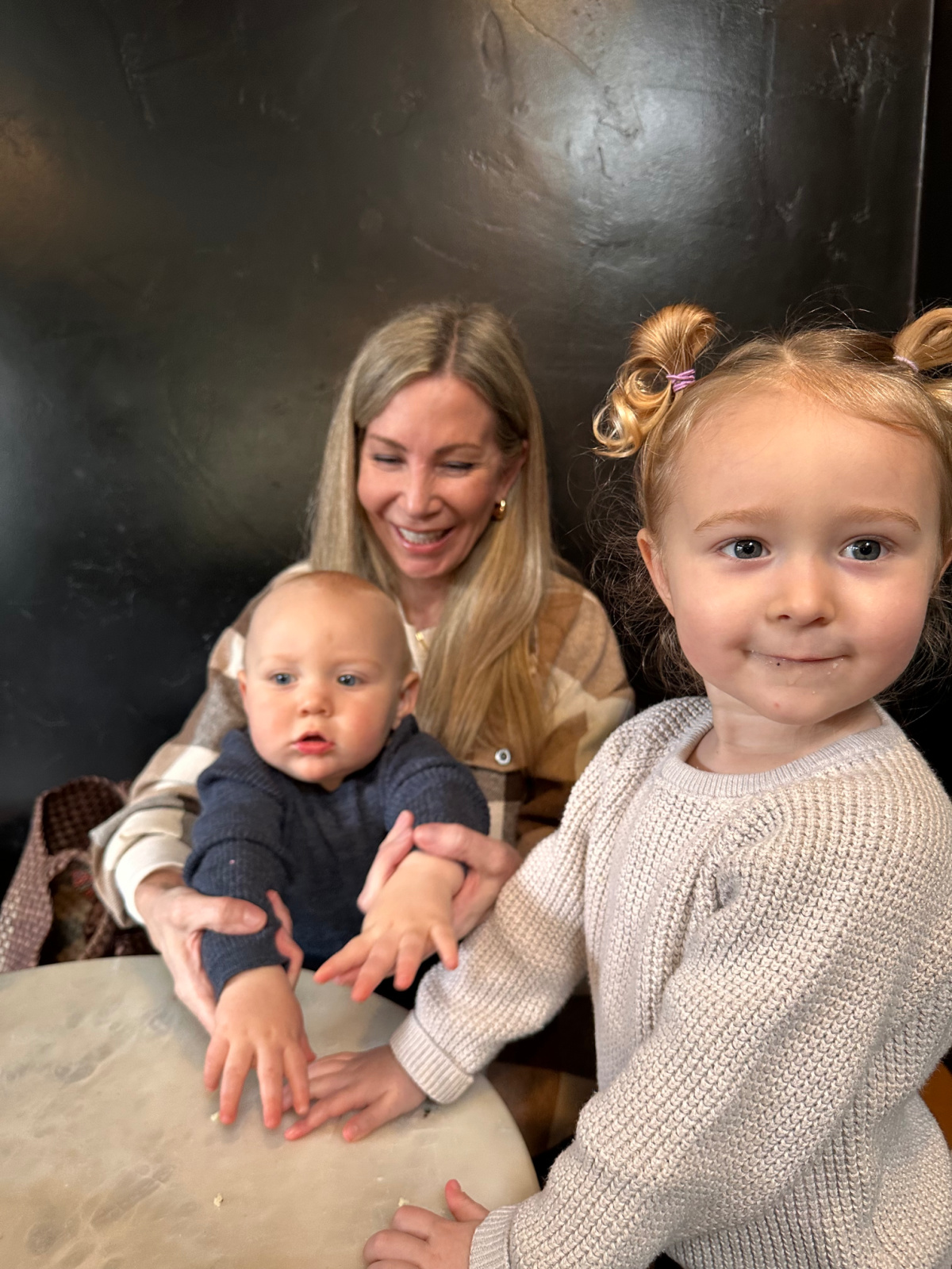 woman sitting with two littles at coffee shop.
