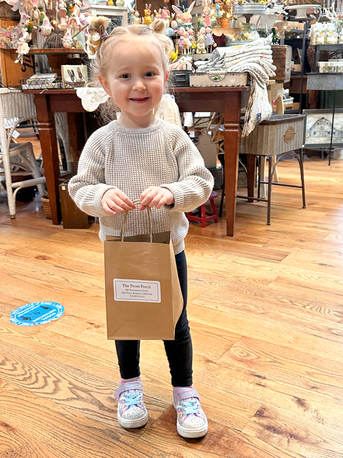 Little girl holding shopping bag in The Front Porch.