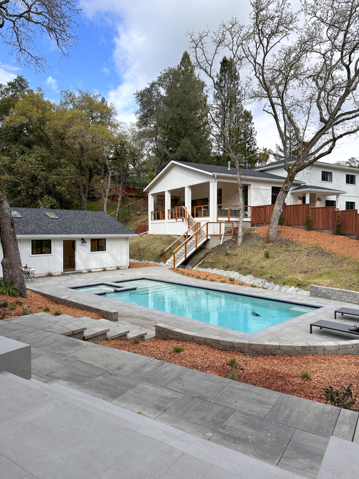 Pool with guest white house and house in background.