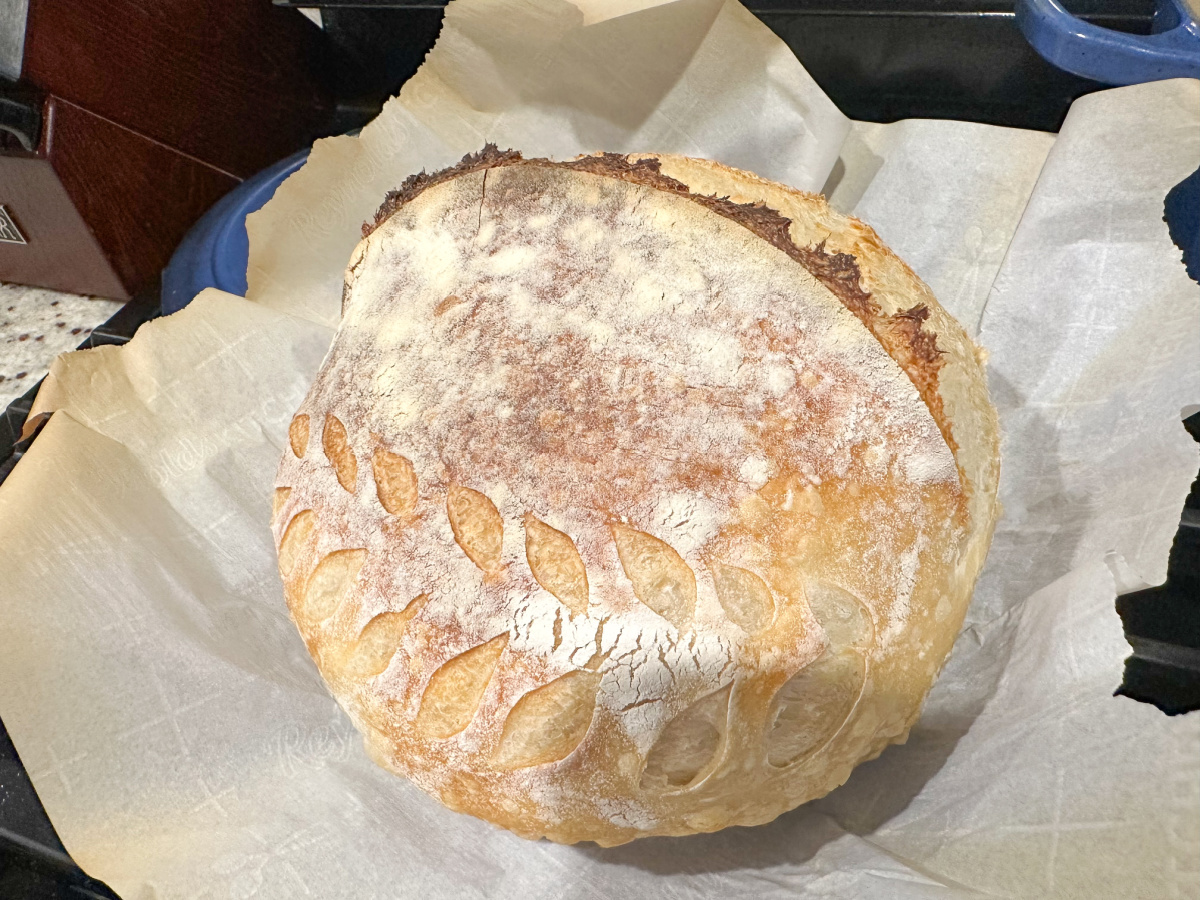 Round sourdough loaf on parchment paper.