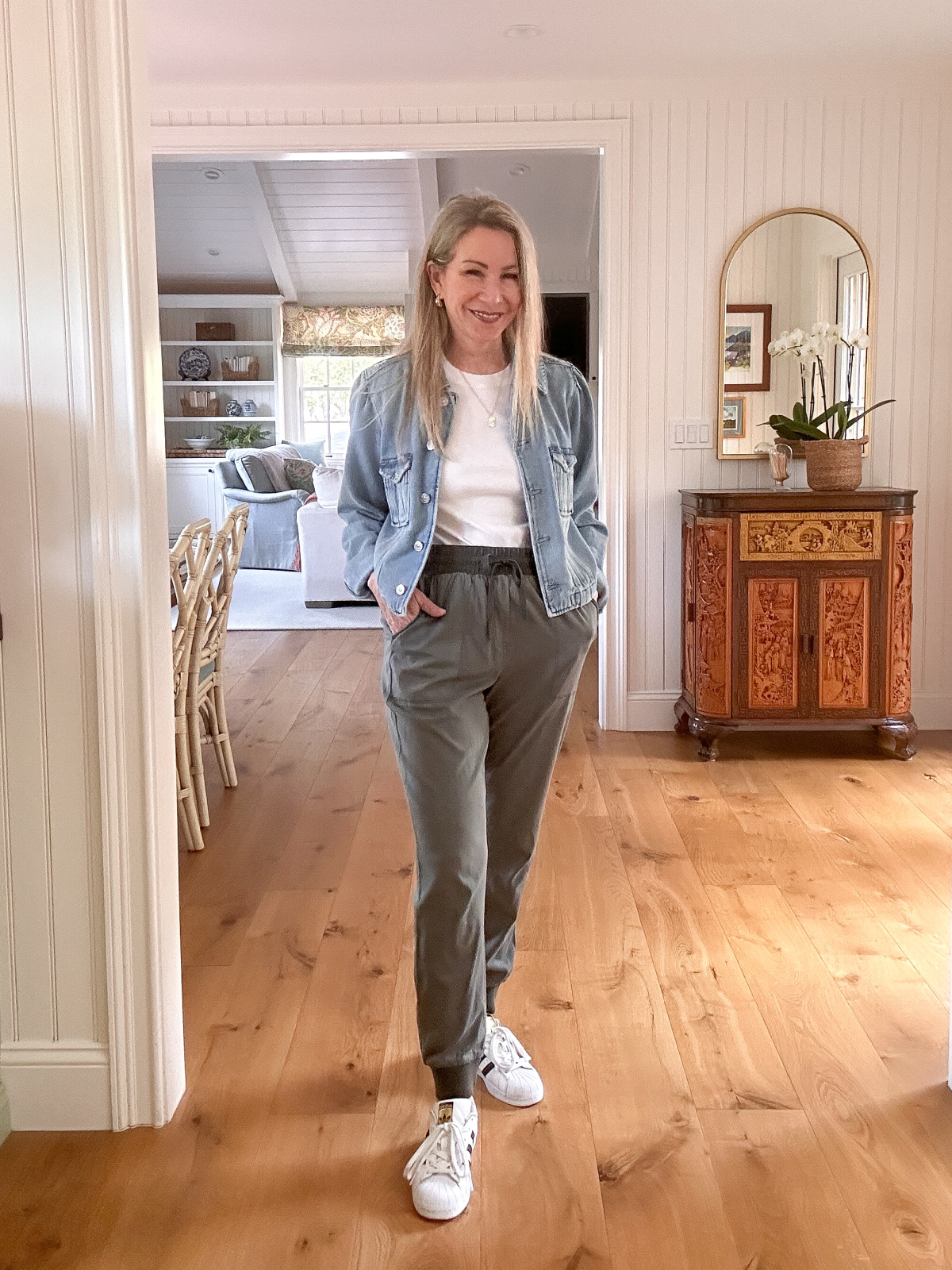 Woman wearing green khaki's, white tee and denim jacket.