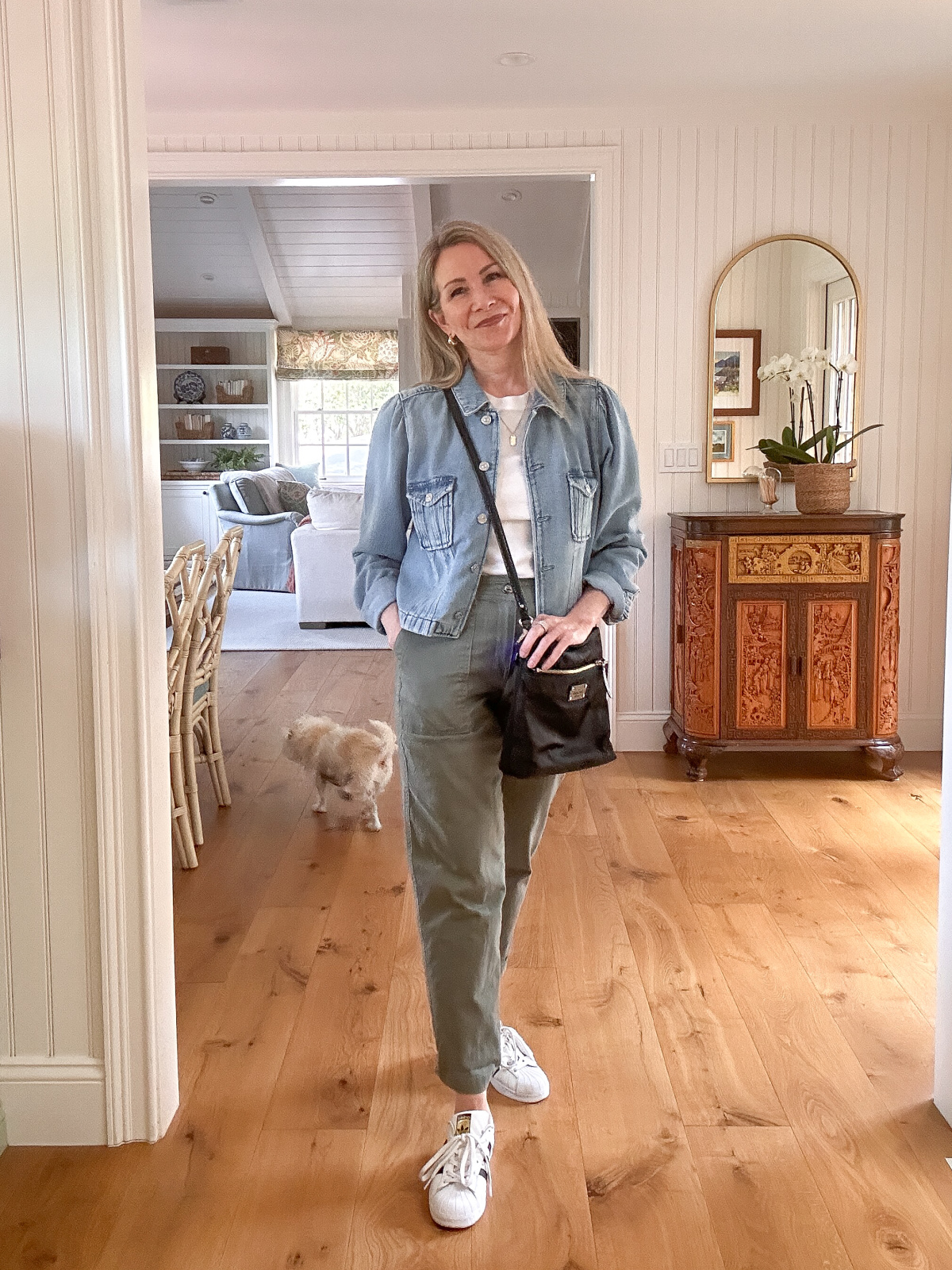 Woman wearing green khaki joggers, white tee and denim jacket.