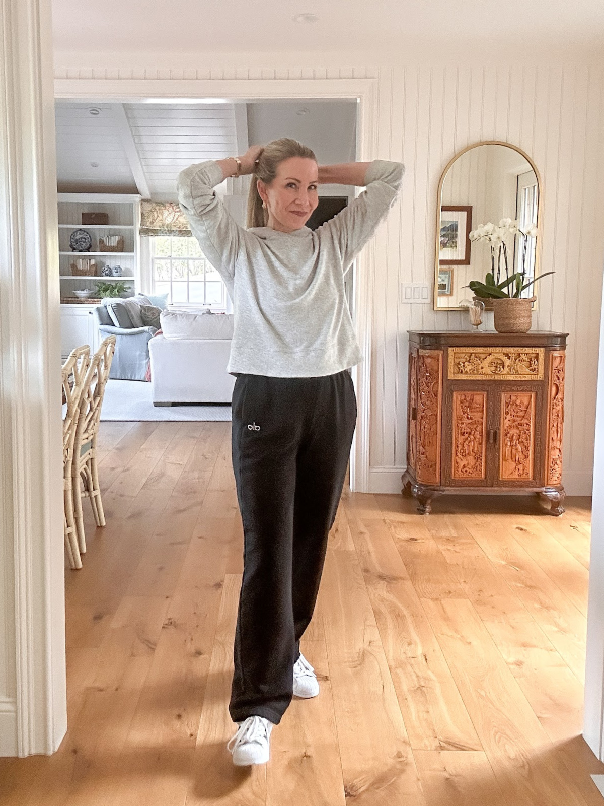 Woman wearing Alo sweatpants and gray hoodie.