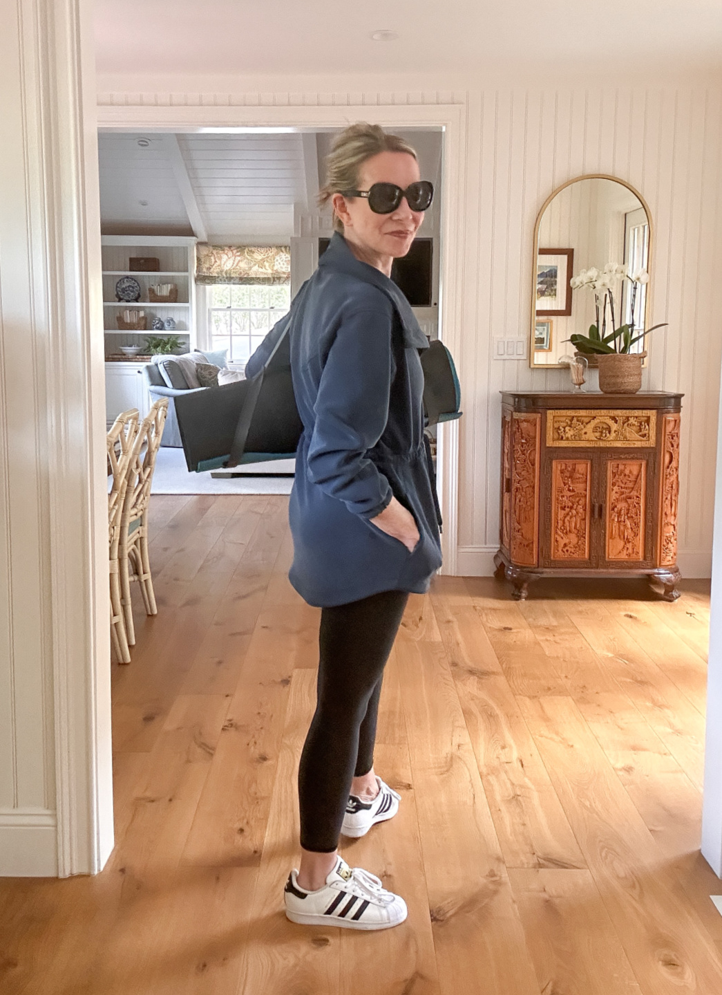 Woman wearing yoga gear holding yoga mat.