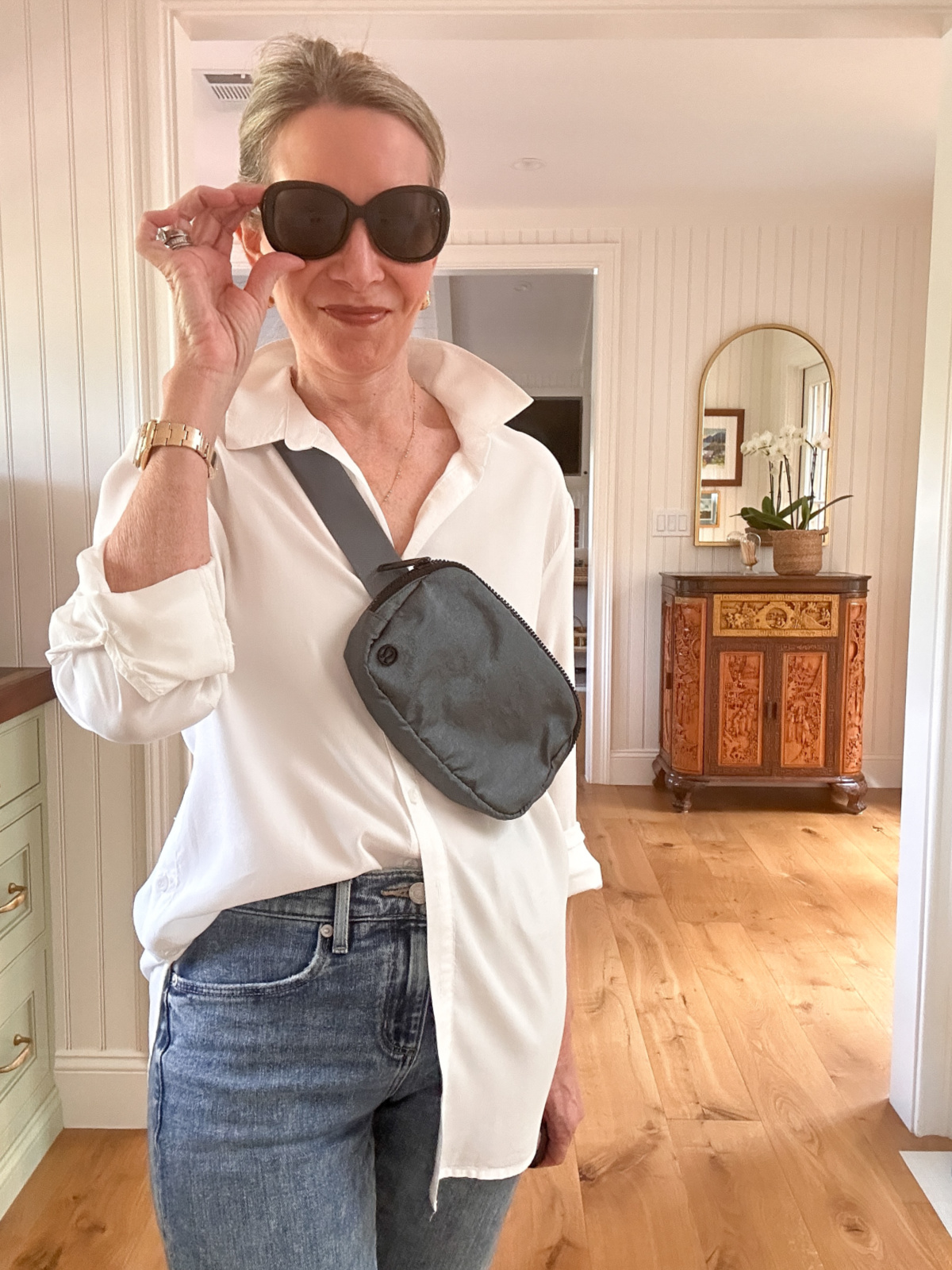 Woman wearing white shirt and jeans with Adidas Superstars.