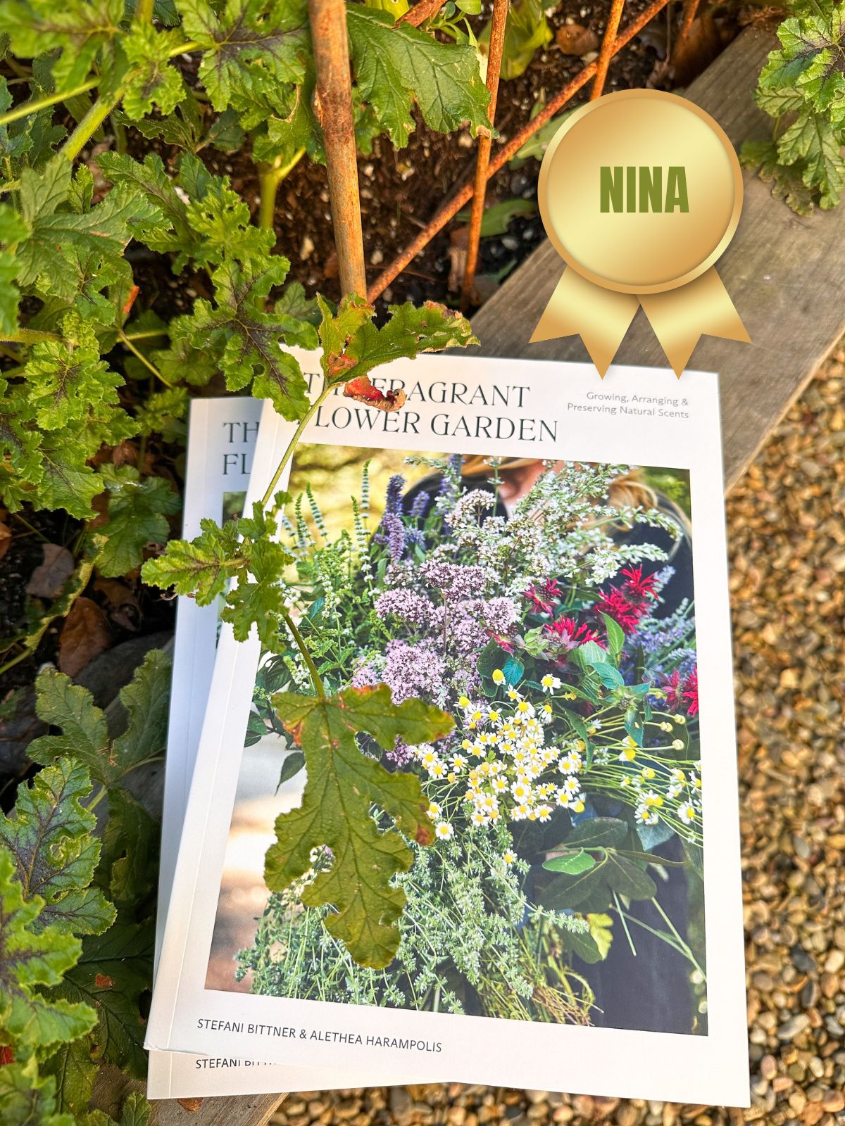 Two copies of the Fragrant Flower Garden book in raised bed garden.