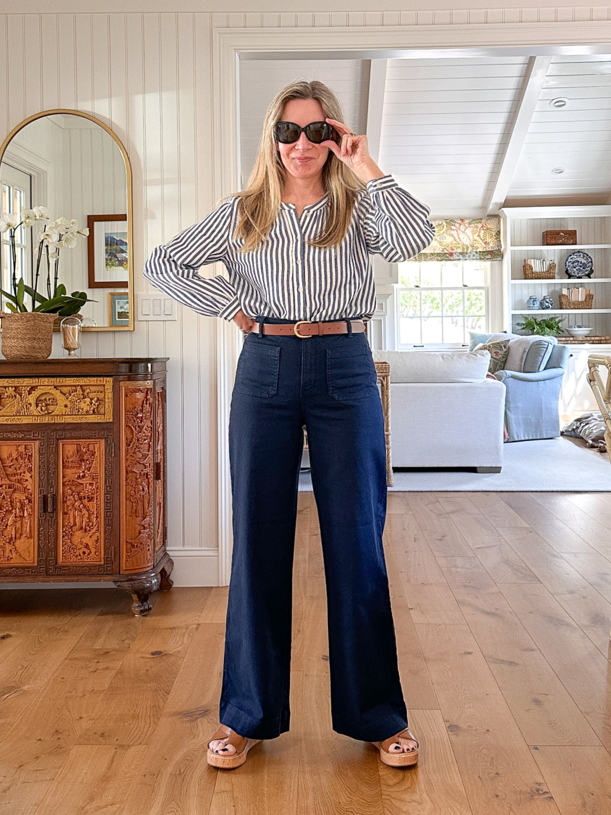Woman wearing wide legged pants and striped shirt.