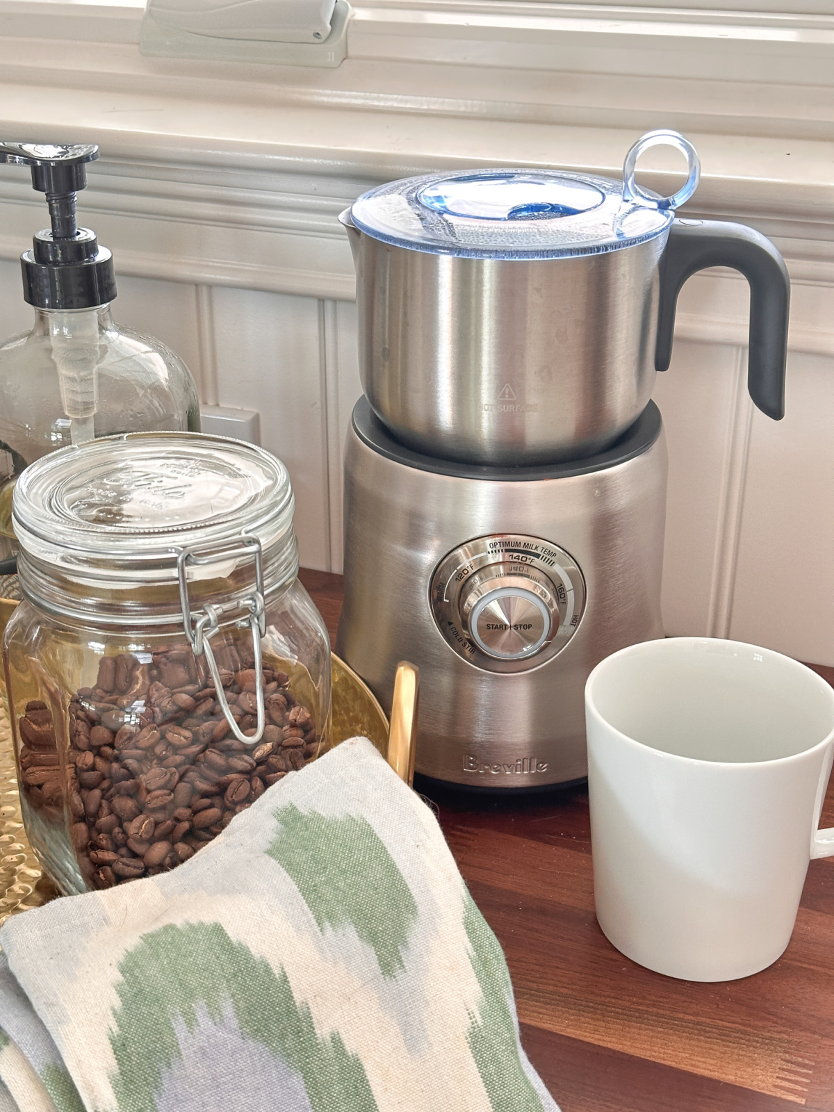 Breville milk brother sitting next to coffee bar tray on counter.