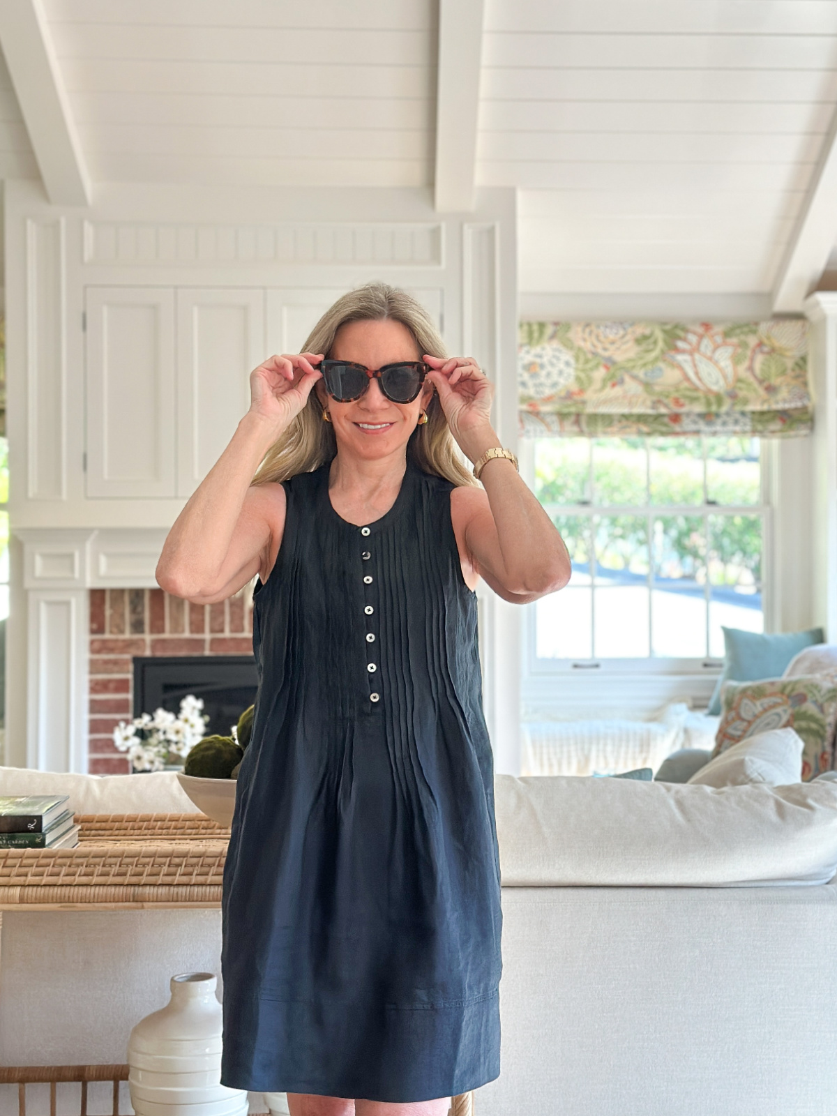 Woman wearing Quince linen dress in black and sunglasses.