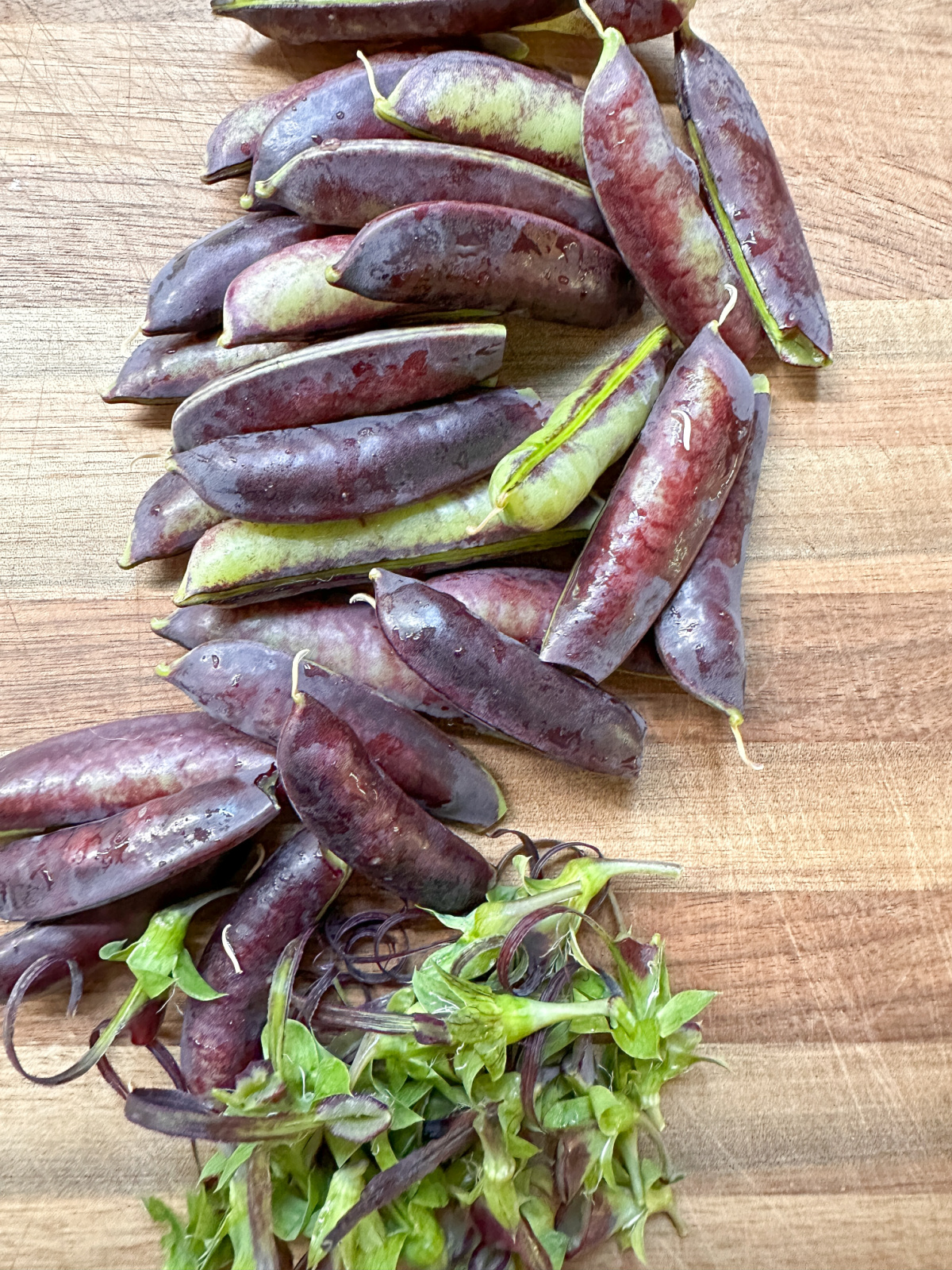Destemmed snap peas on cutting board.