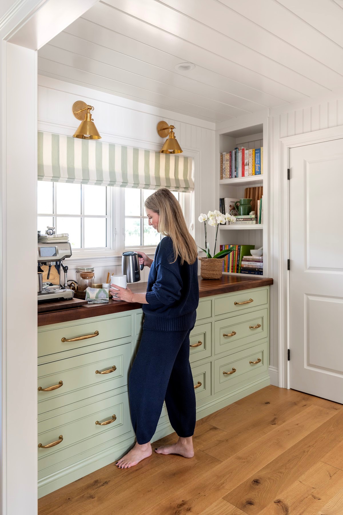 Woman in kitchen pouring cocoa into mug.