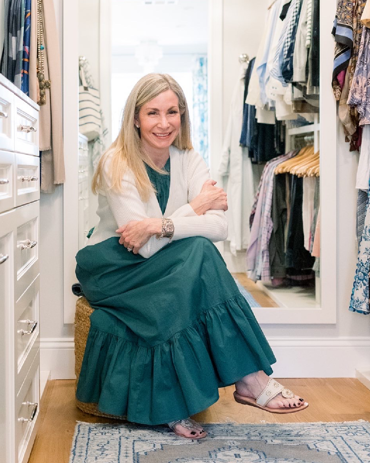 Woman sitting in walk-in closet wearing Jack Rogers sandals.