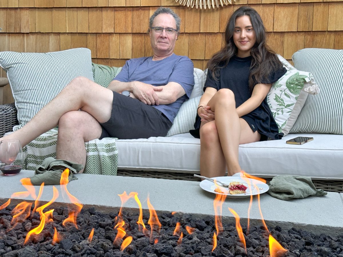 Family sitting around fire table with dessert.