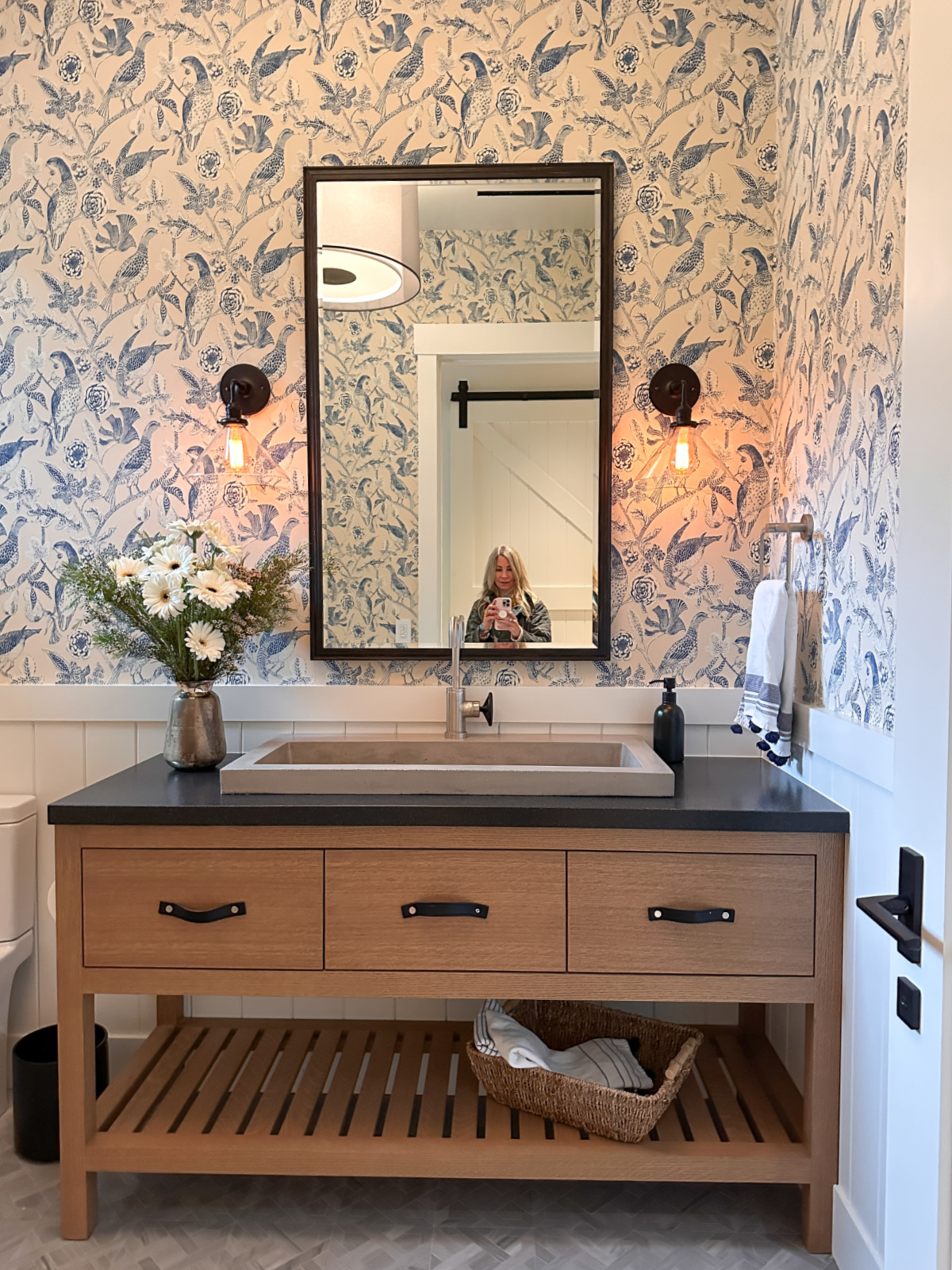 Powder room with pretty blue and white wallpaper.