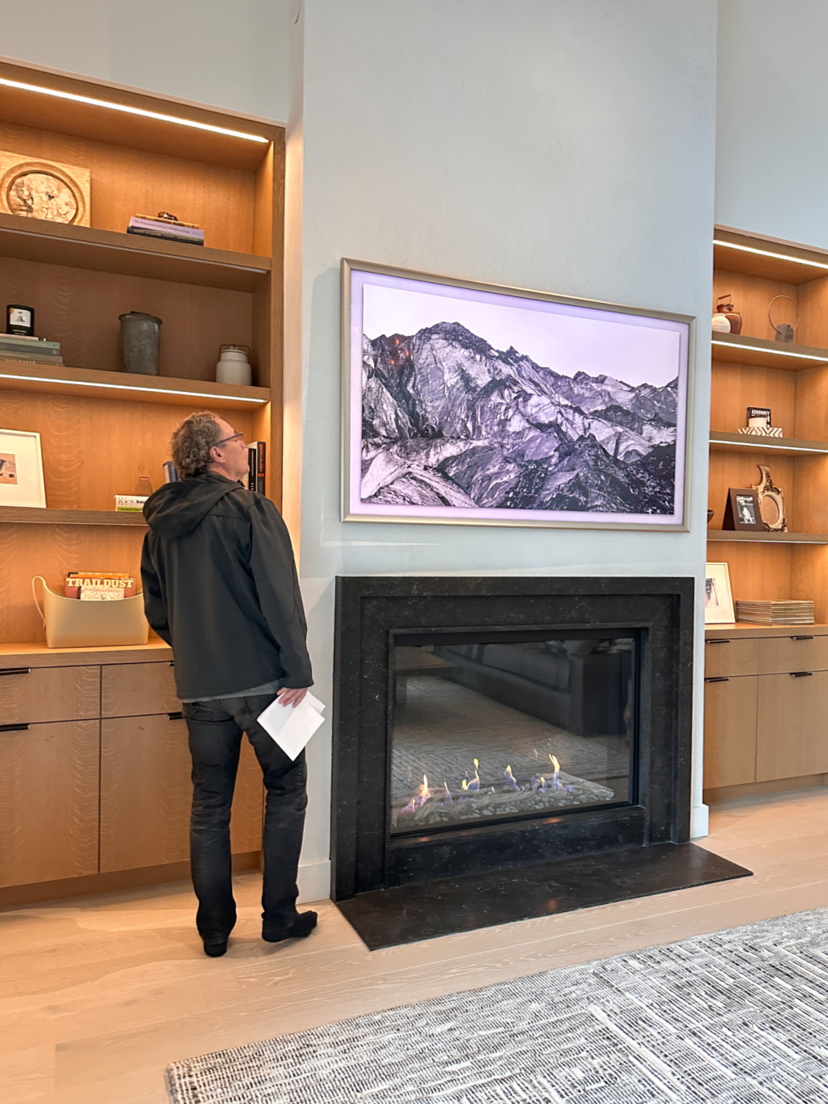 Man looking at mantle in large great room.