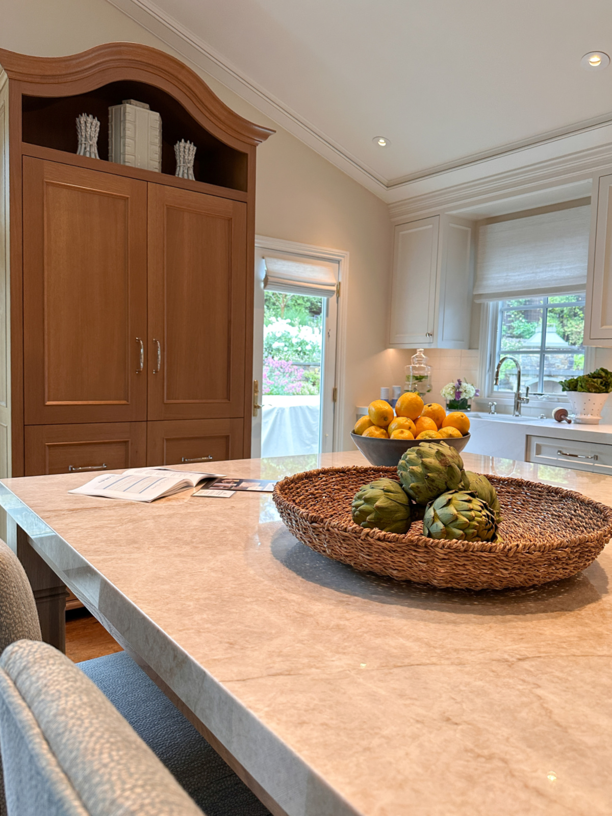 View across kitchen island to built in cabinet, back door and secondary sink.
