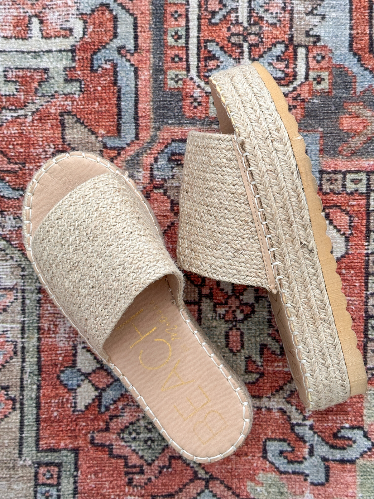 Del Mar sandals on colorful rug.