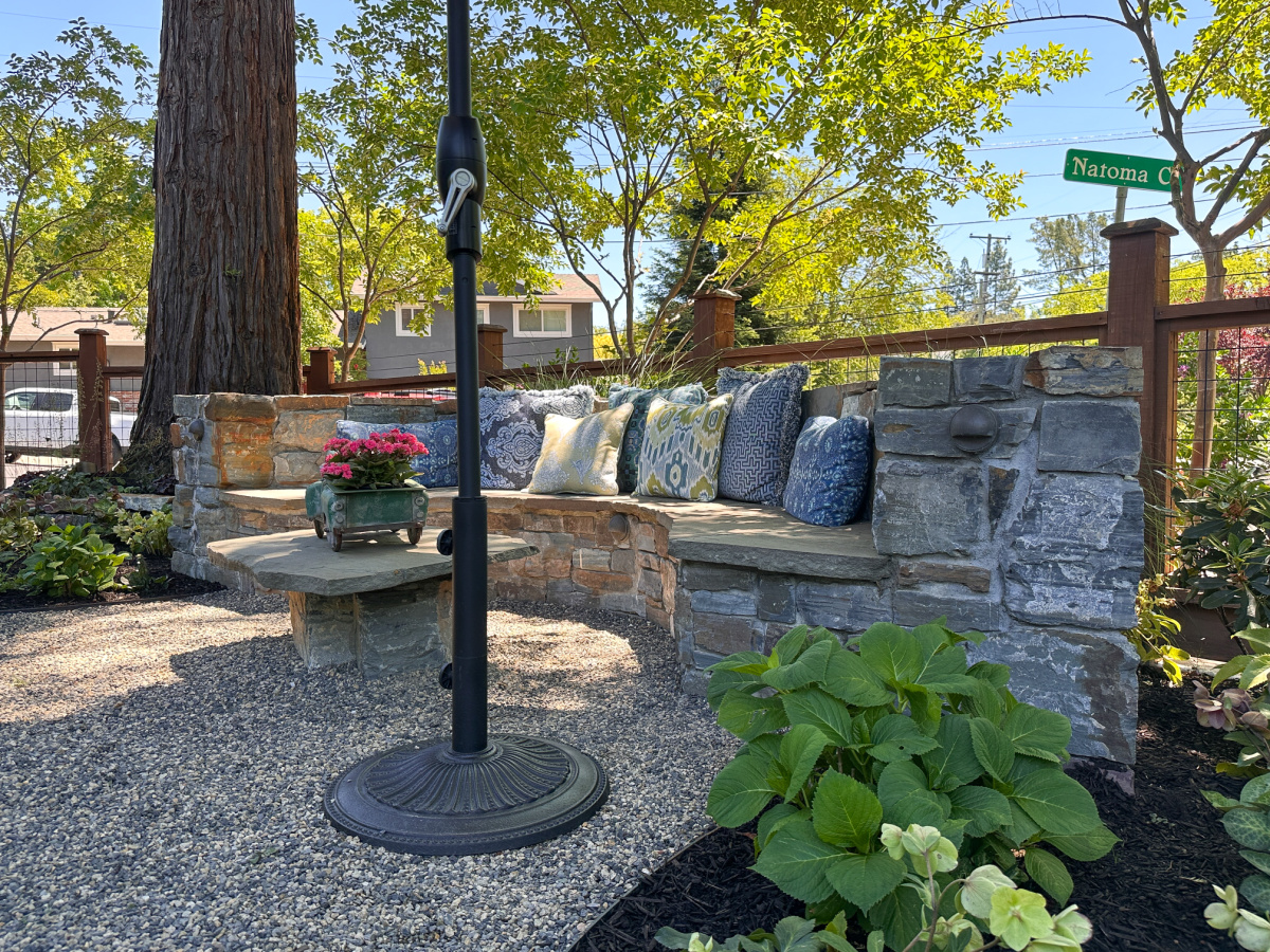 Built in rounded stone bench in front yard garden.