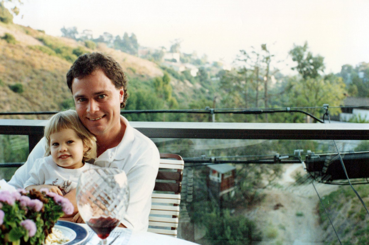 Dad holding young son in his lap at table.