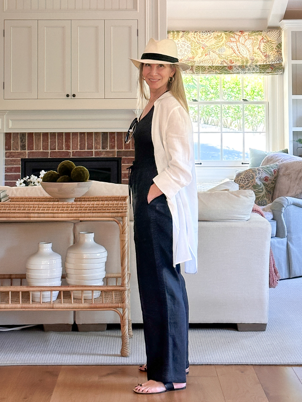 Woman wearing black pants and t-shirt and oversized white shirt.