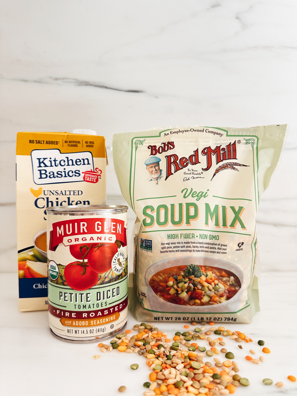 A bag of soup mix, chicken broth and diced tomatoes on counter.