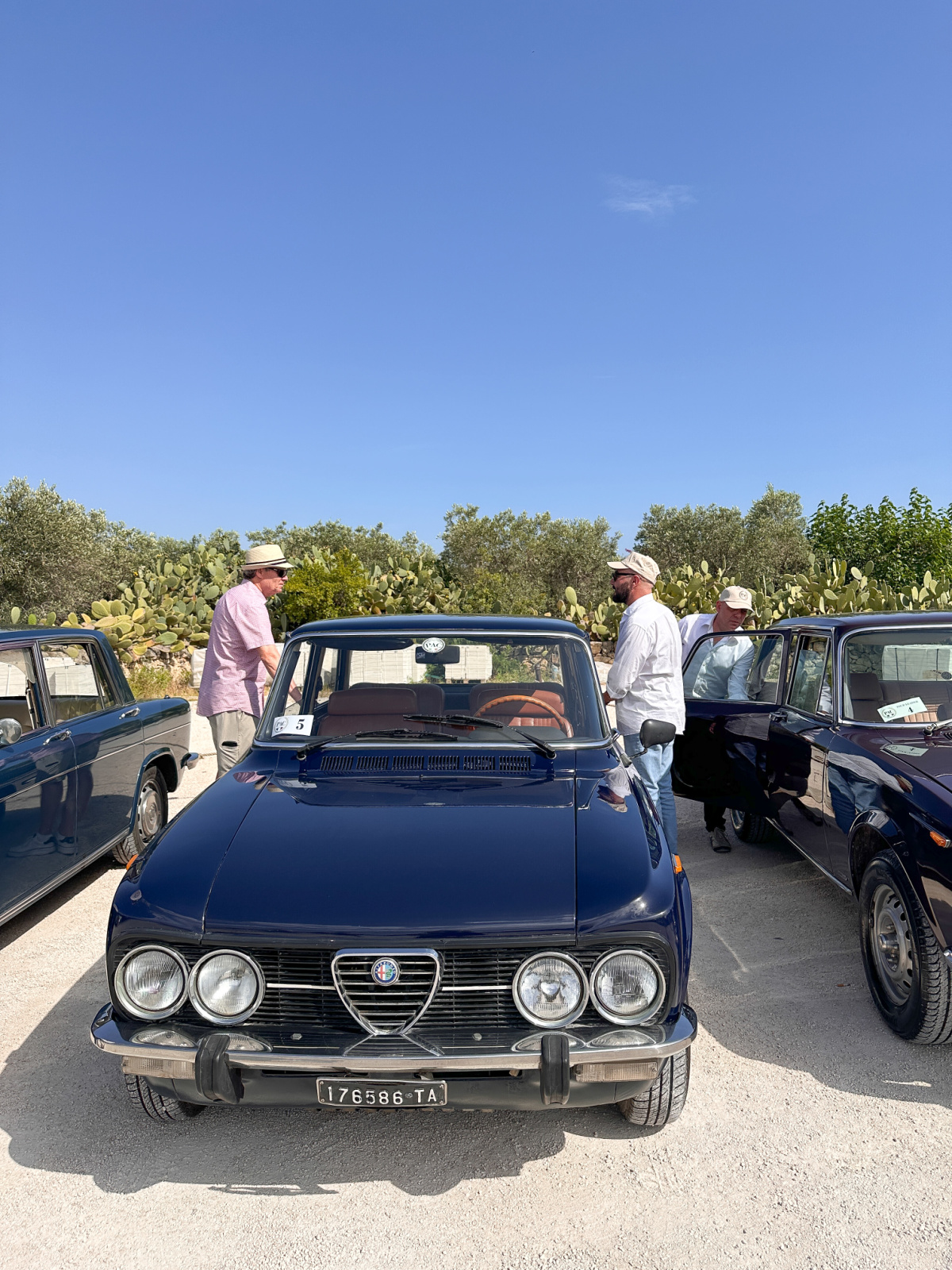 Two men getting into vintage Italian car.