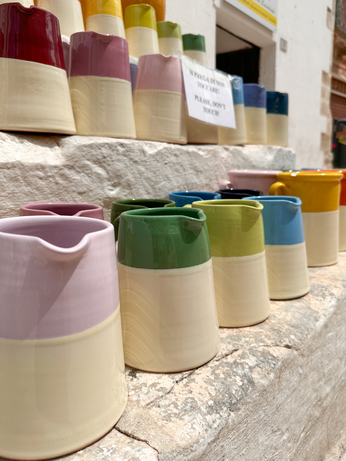 Colorful ceramic pitchers on display in Locorotondo, Italy.