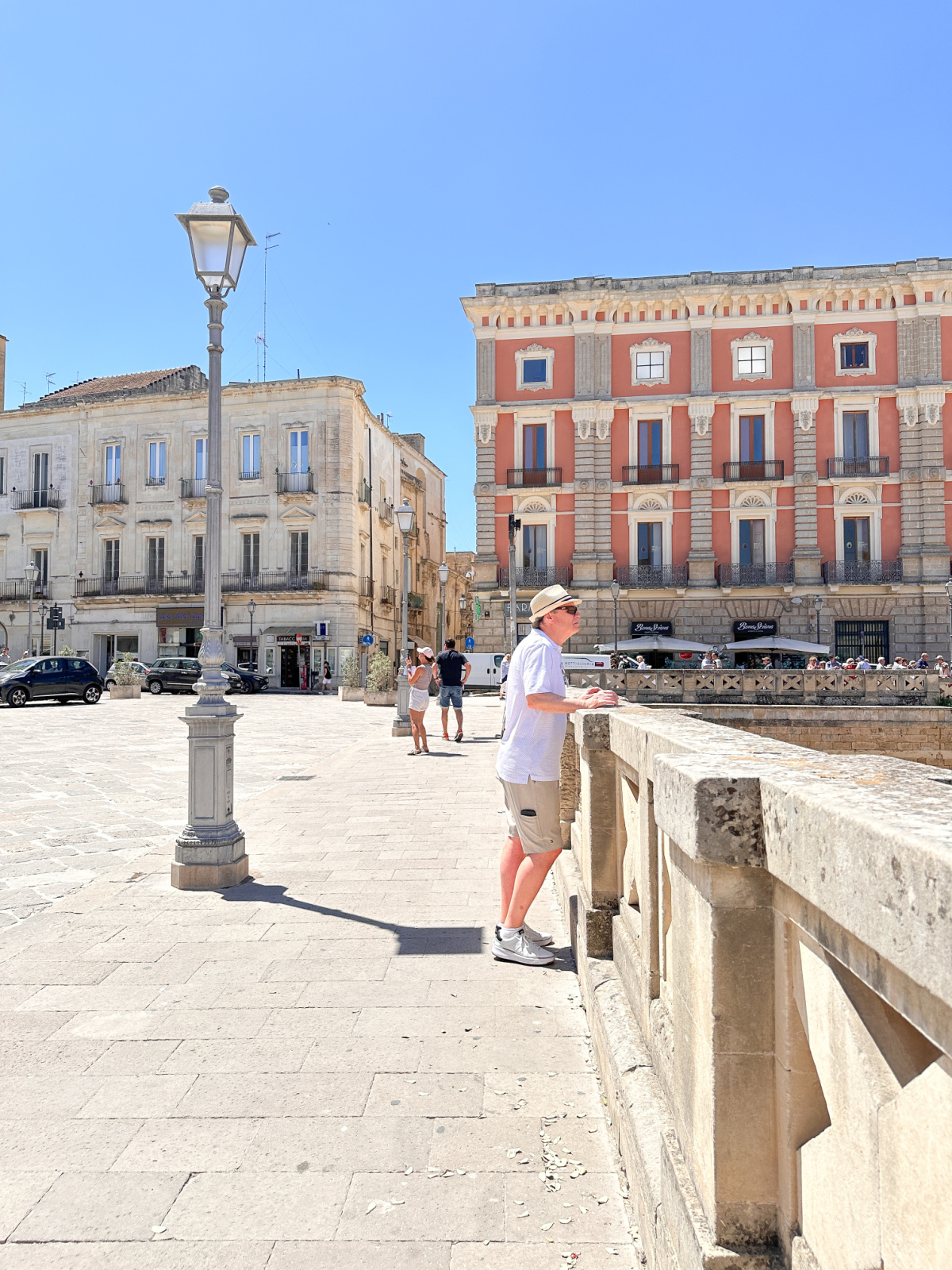 Man looking down at Roman ruins in Lecce.