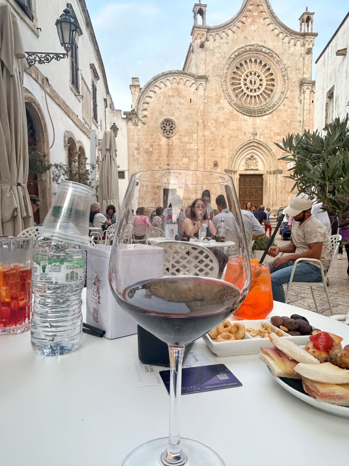 Glass of wine on table in front of Catholic Church in Ostuni.