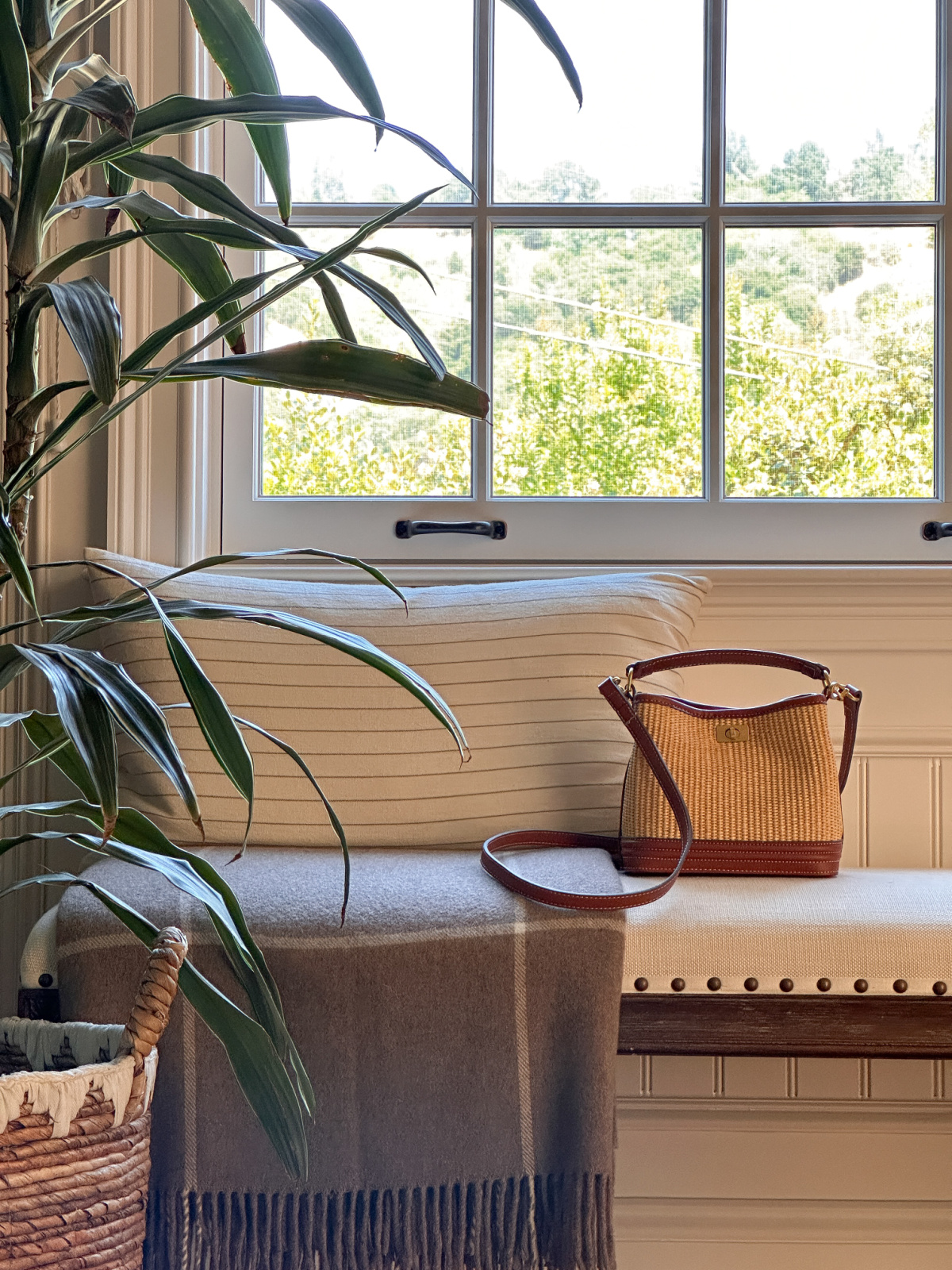 Mango raffia-like bucket bag sitting on under window bench.