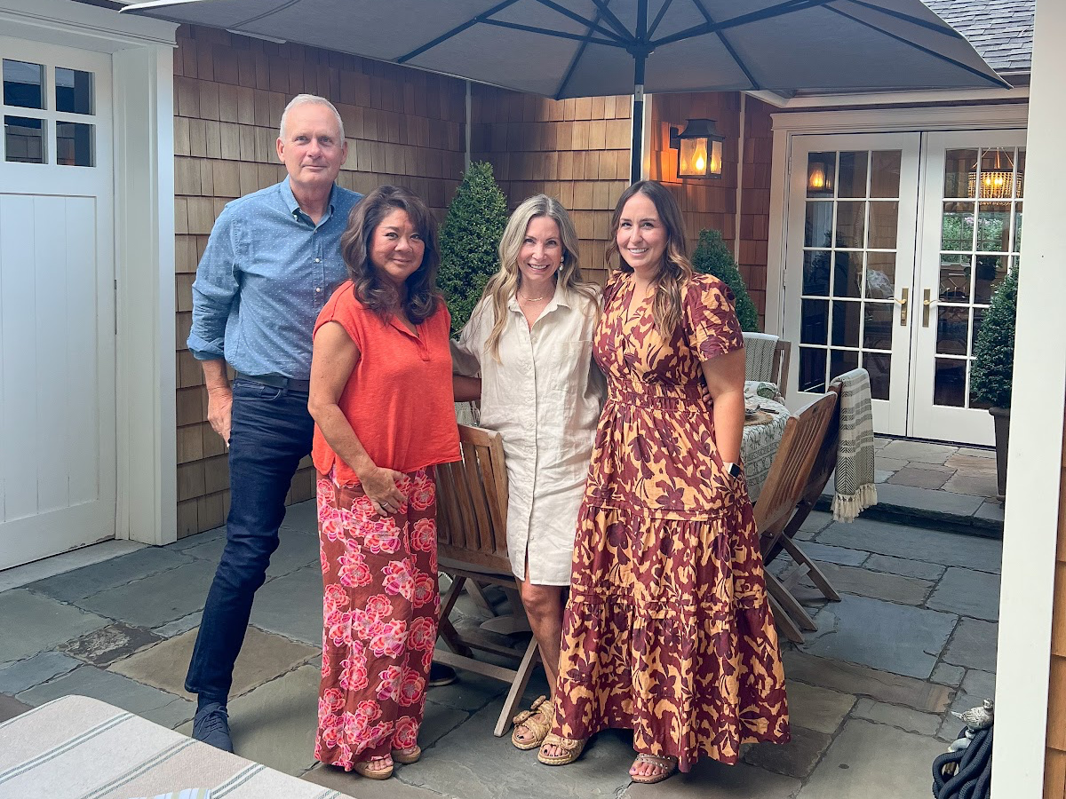 Four friends standing on patio before al fresco dinner.
