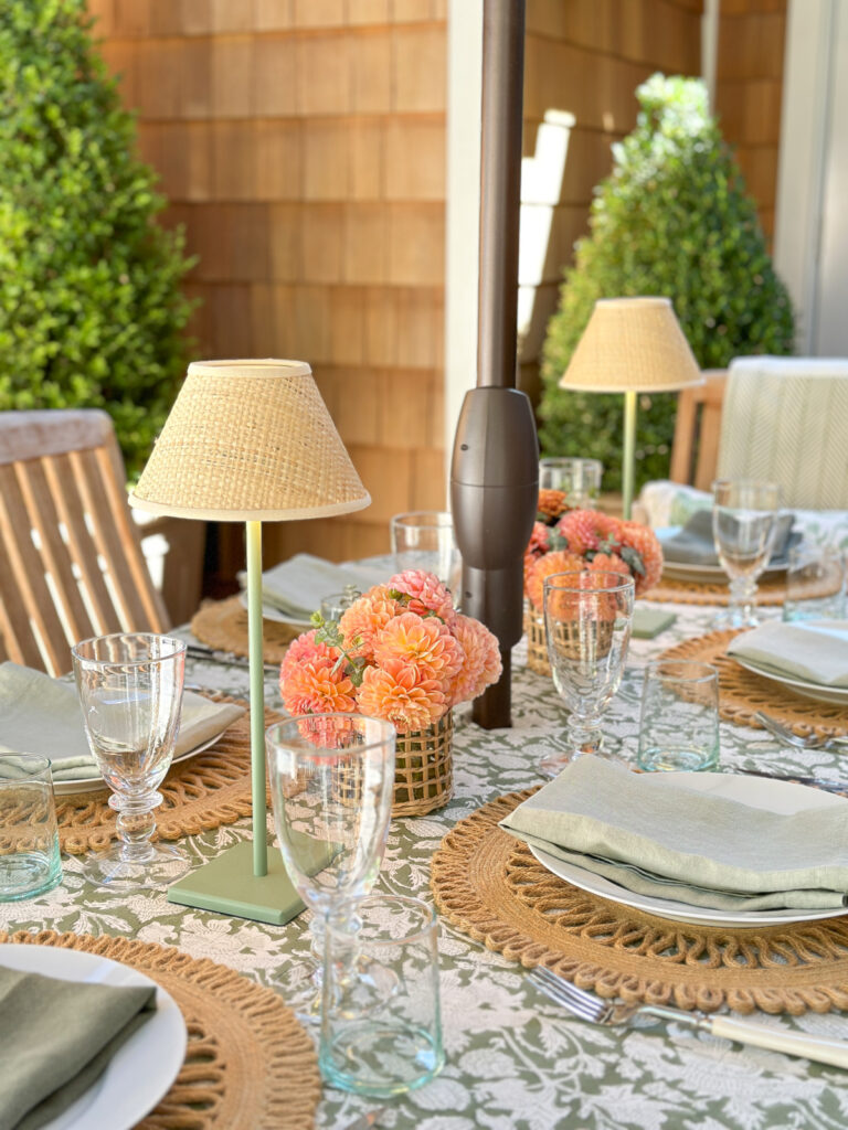 Green and white tables setting with coral flowers.