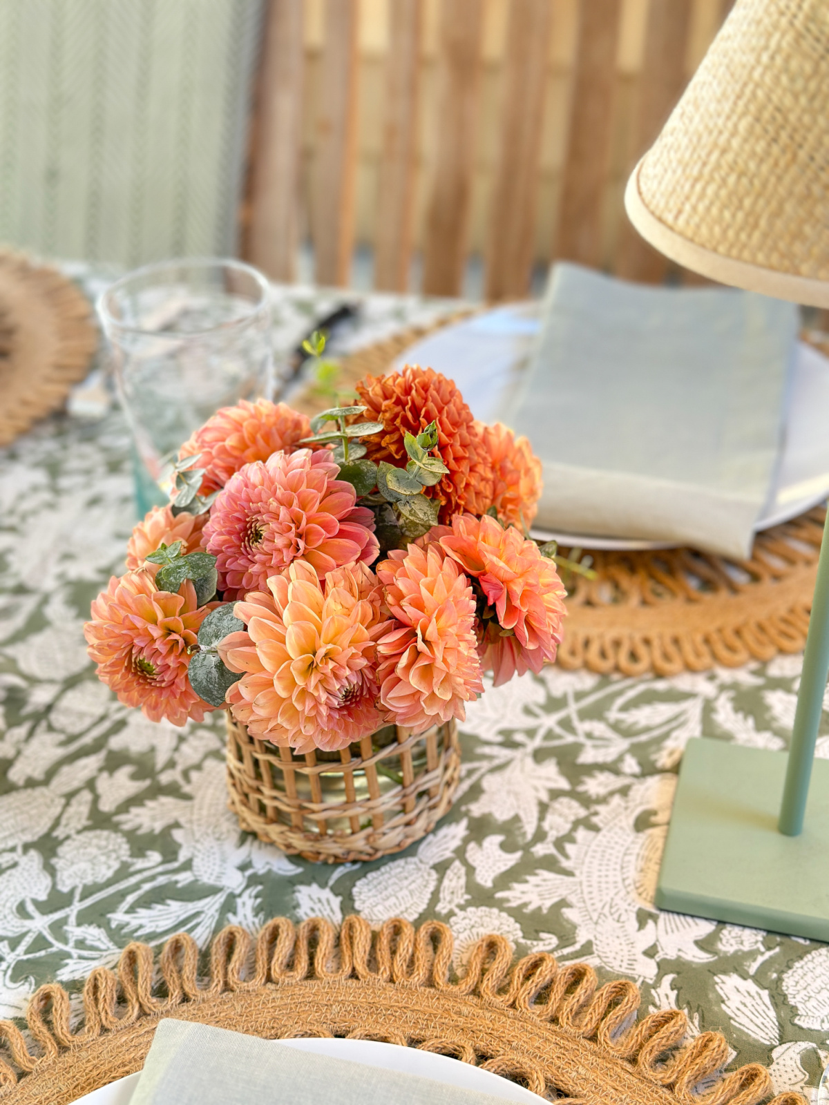 Coral dahlias in small outdoor table arrangement.