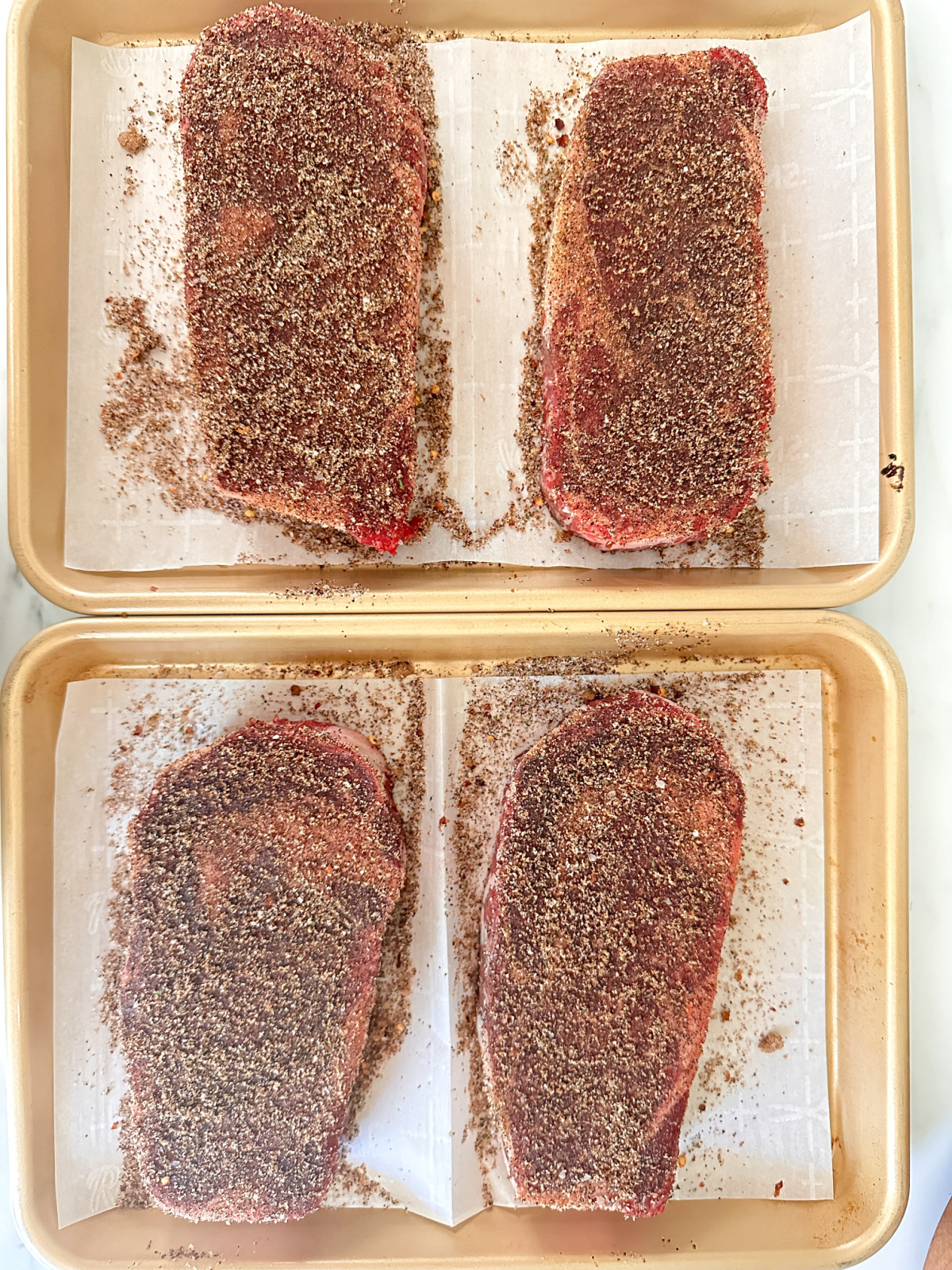 Rib eyes marinating in a dry rub.