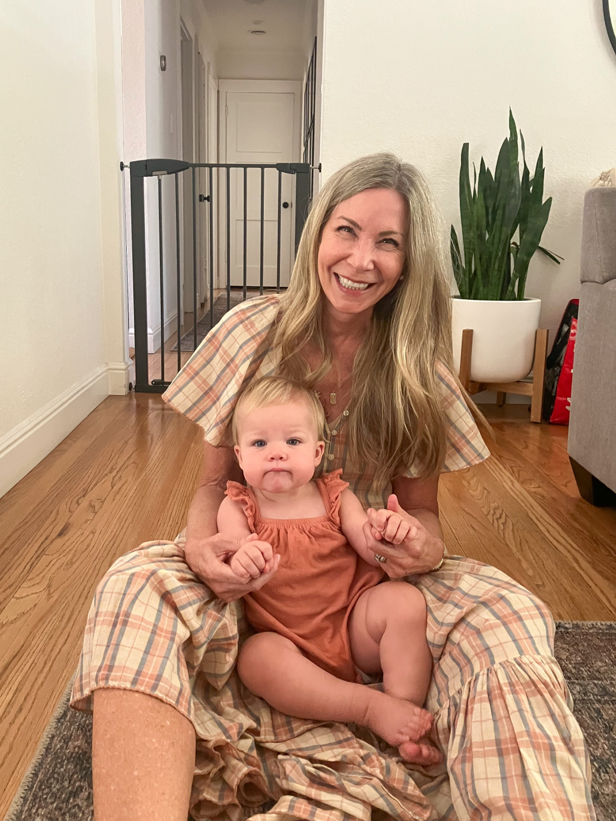 Woman sitting on floor with holding baby girl.
