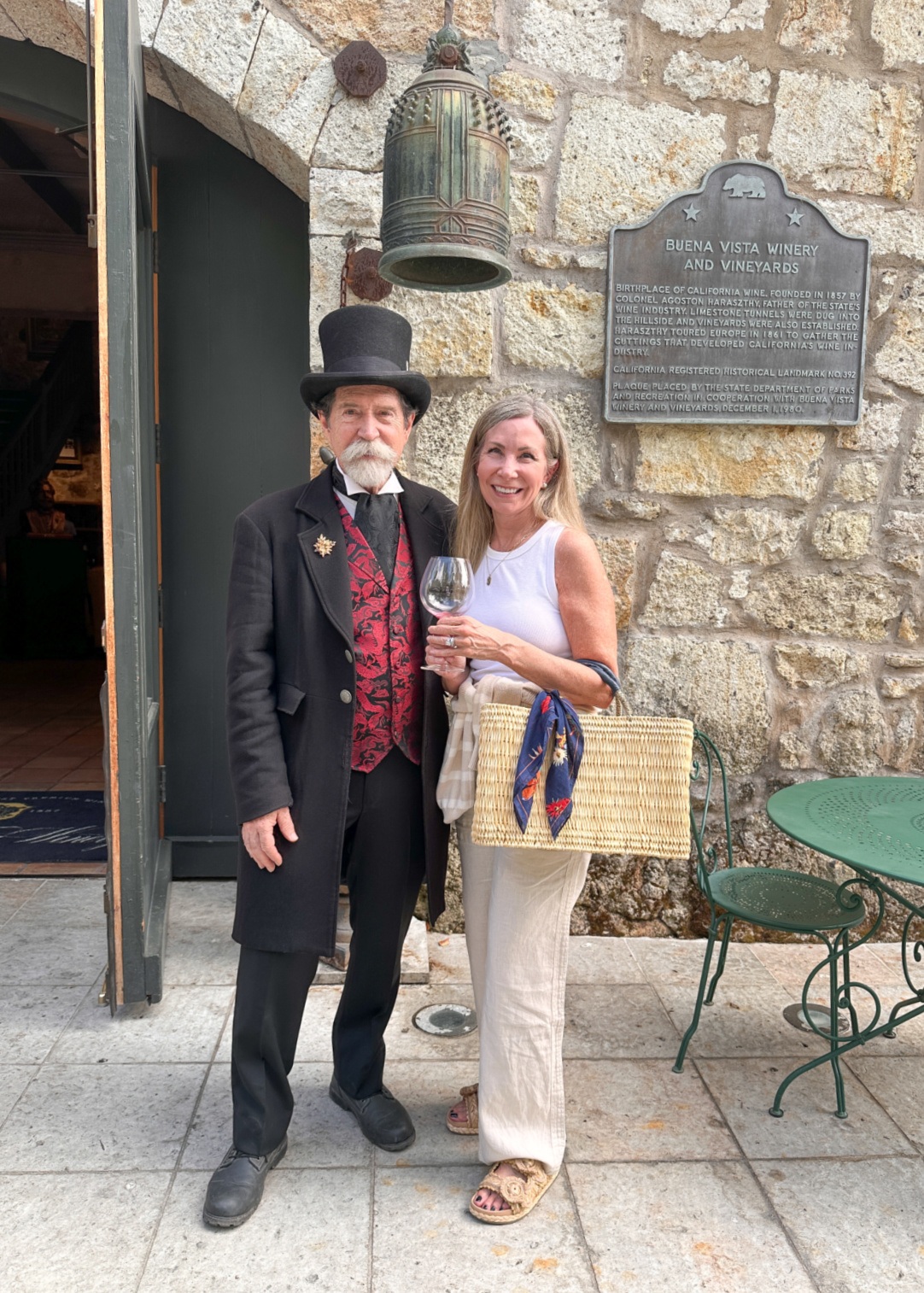 Woman holding wine glass standing next to the Count at Buena Vista Winery.