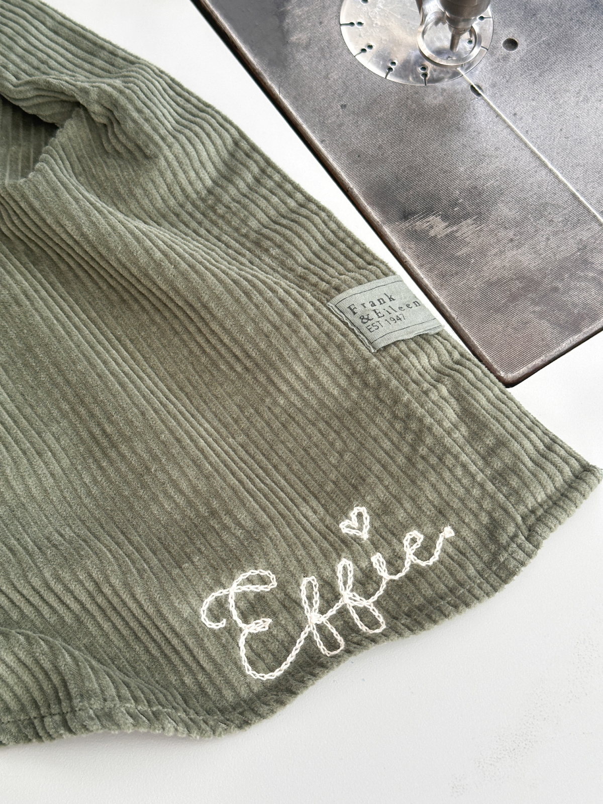 Green corduroy shirt tail with embroidered name.