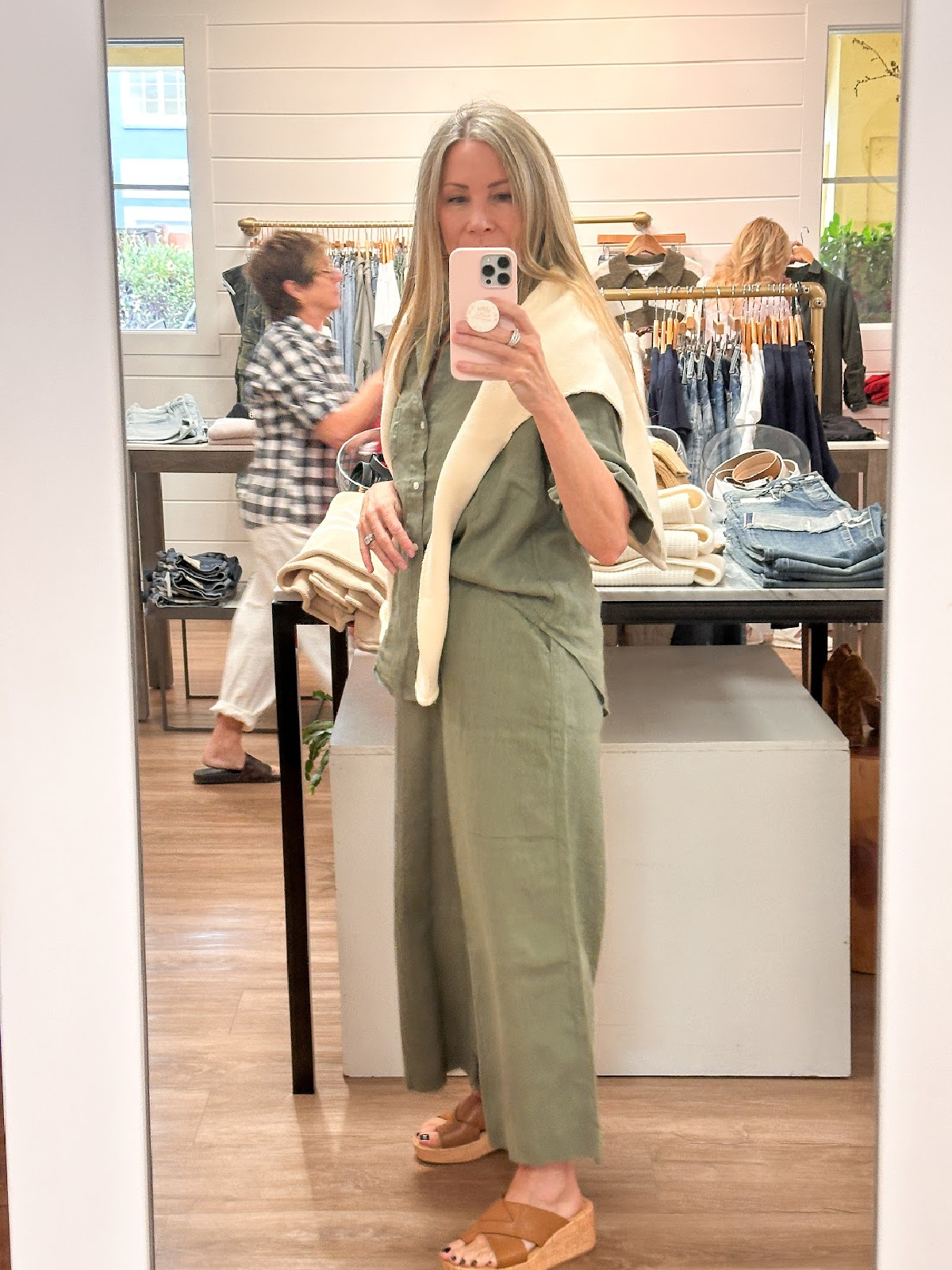 Woman wearing green linen set thing selfie in Flaunt boutique.