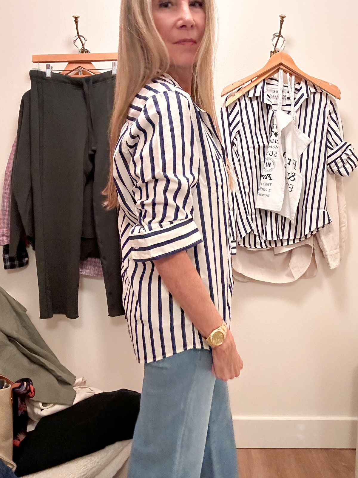 Woman taking dressing room selfie wearing Frank & Eileen striped button down and jeans.