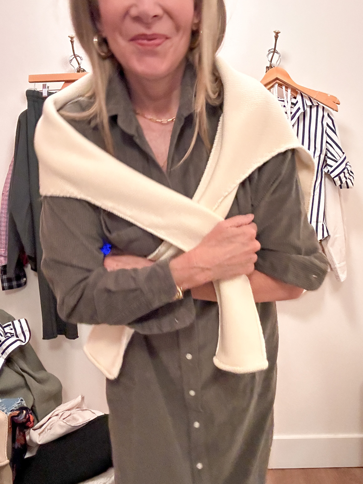 Woman wearing Frank & Eileen olive green shirt dress and ivory sweater over shoulders.