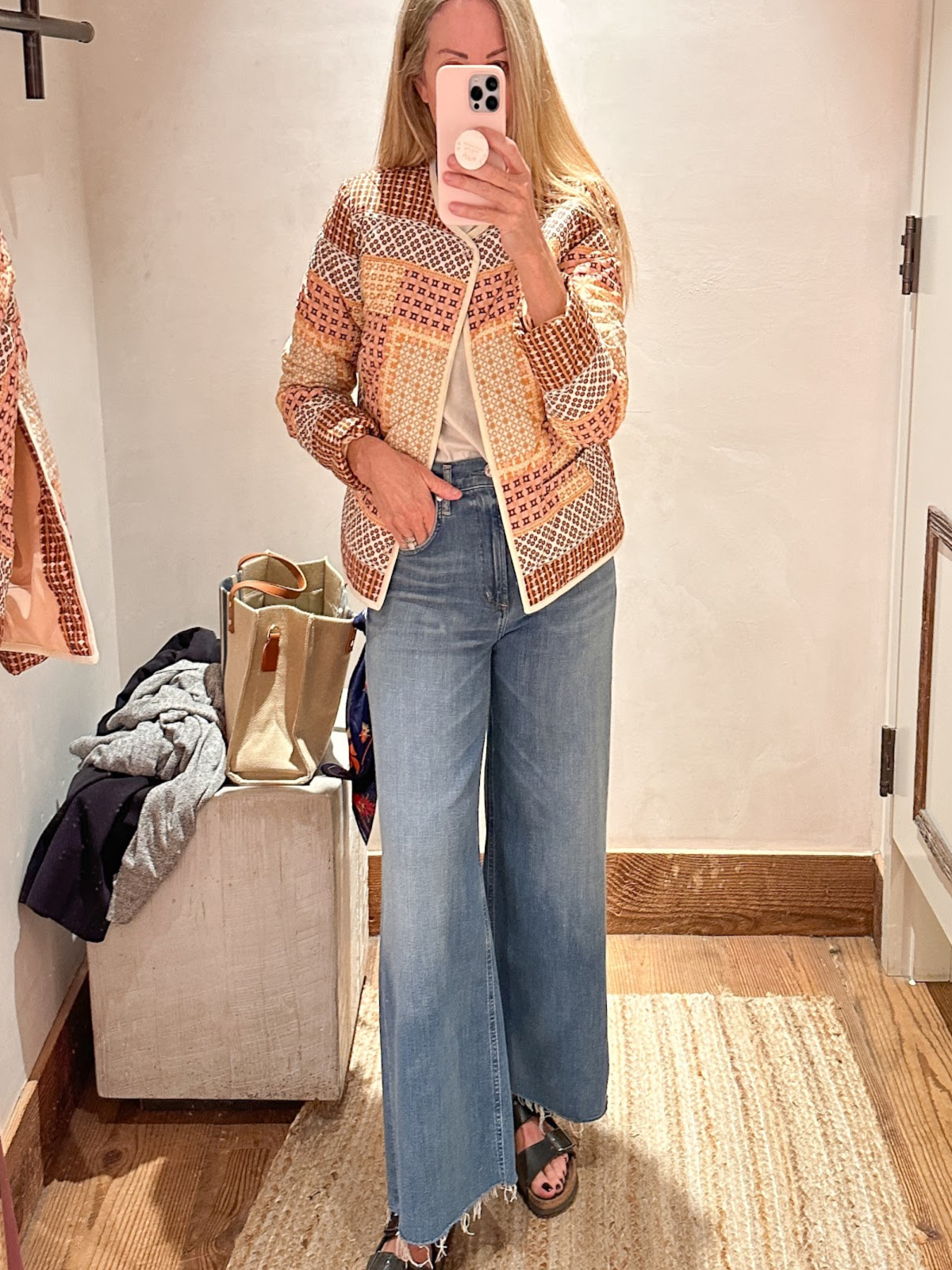 Woman trying on jeans and quilts jacket at Anthropology.
