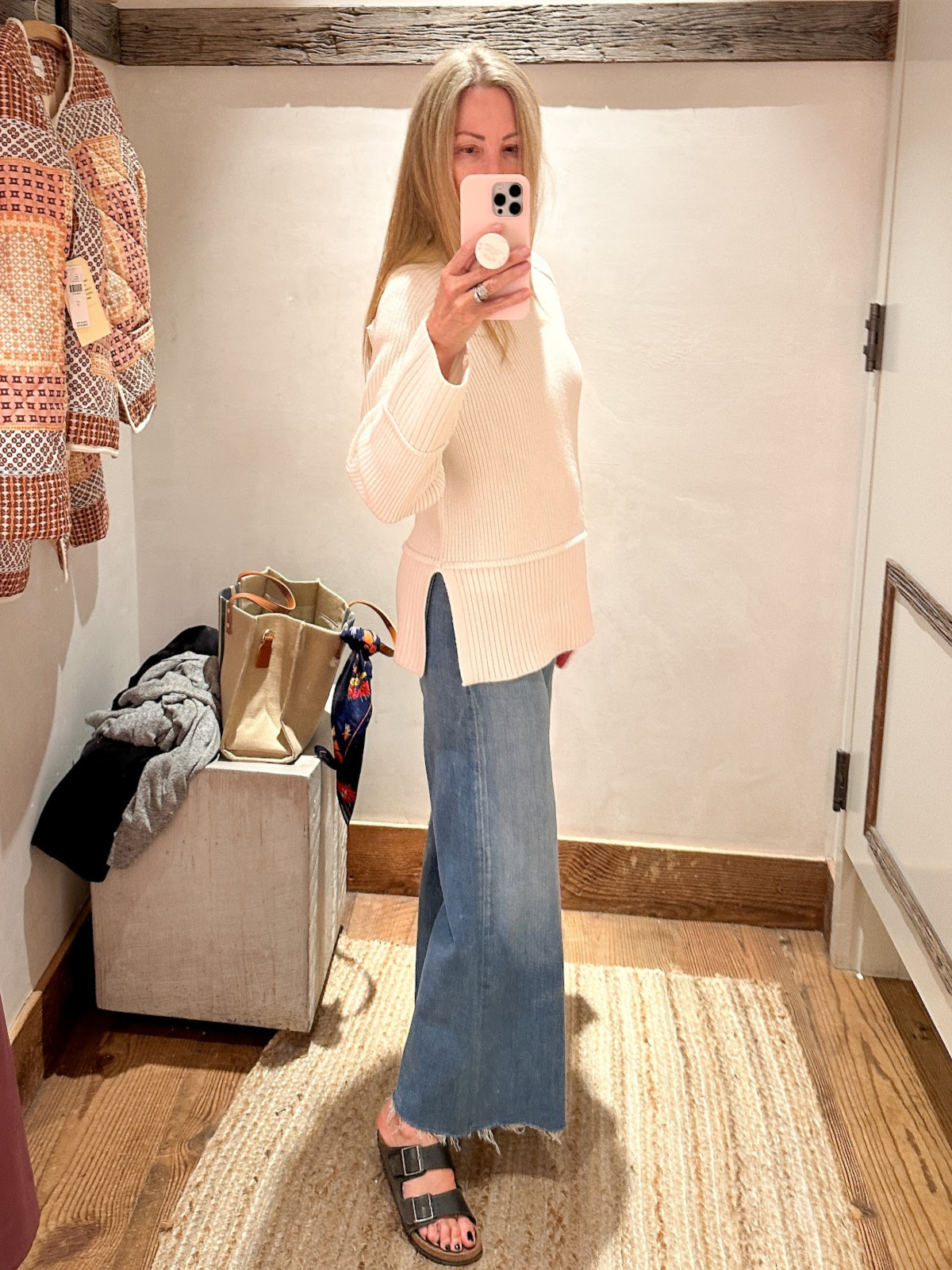 Woman trying on sweater and jeans at Anthropology.