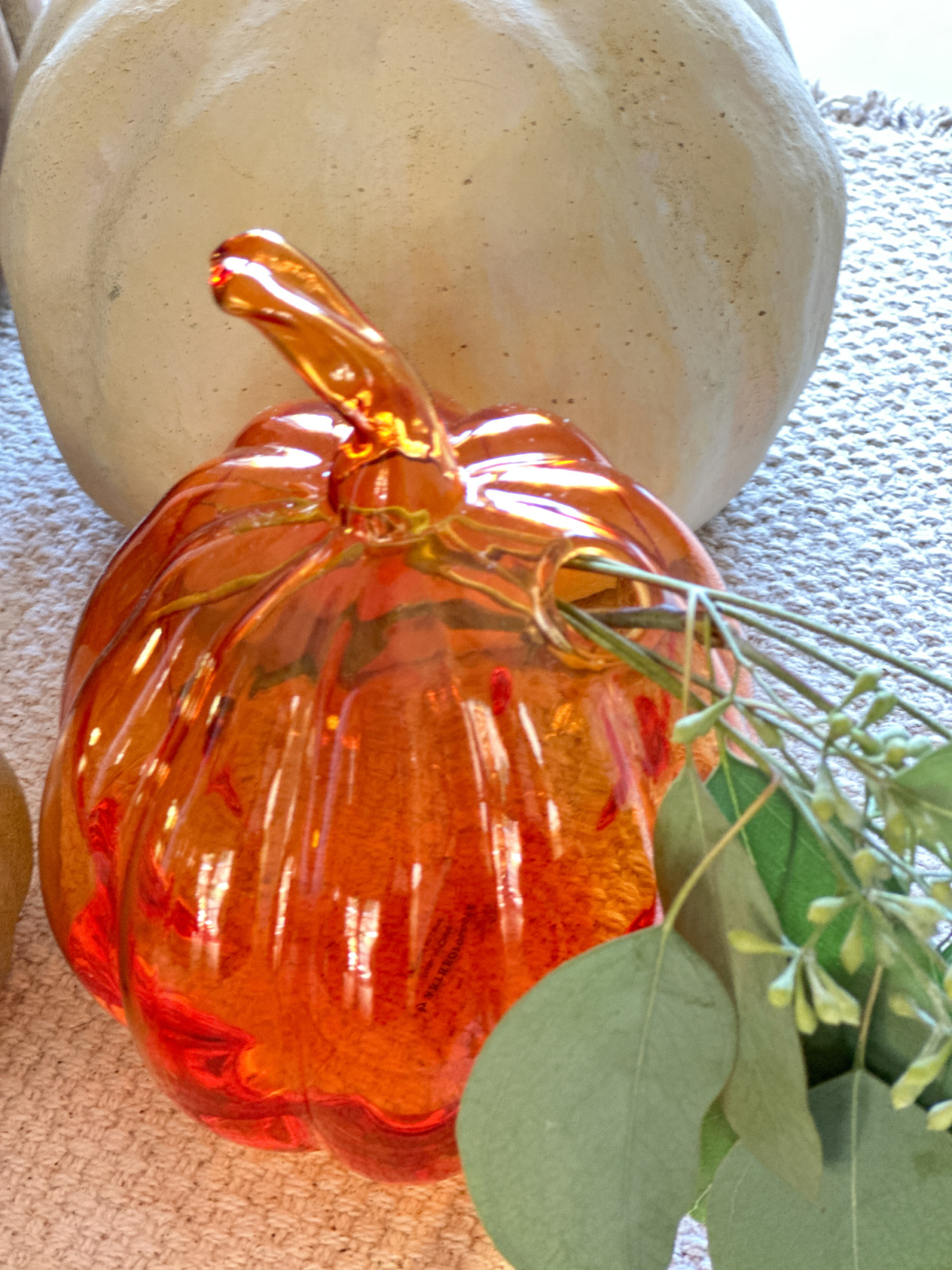 Amber glass pumpkin shaped bud vase as part of fall table centerpiece.