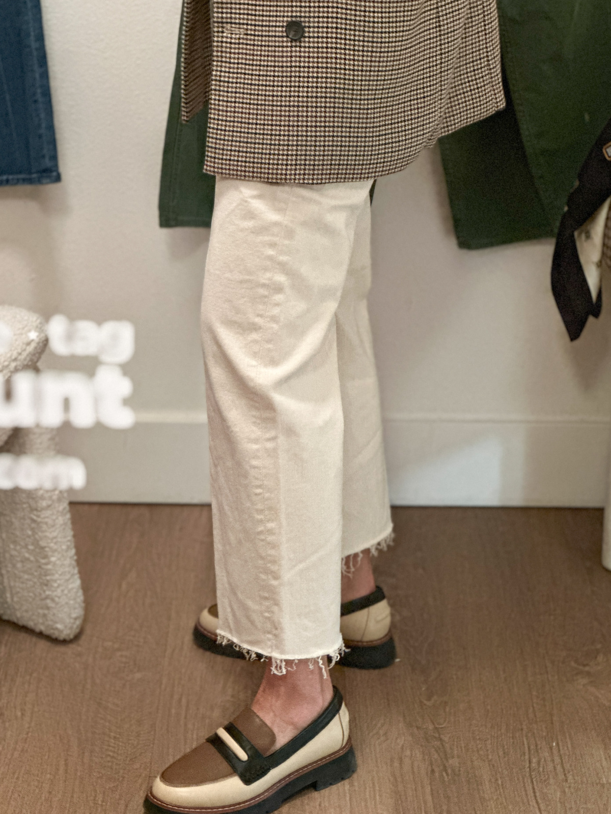 Woman trying on warm white Mother Denim.