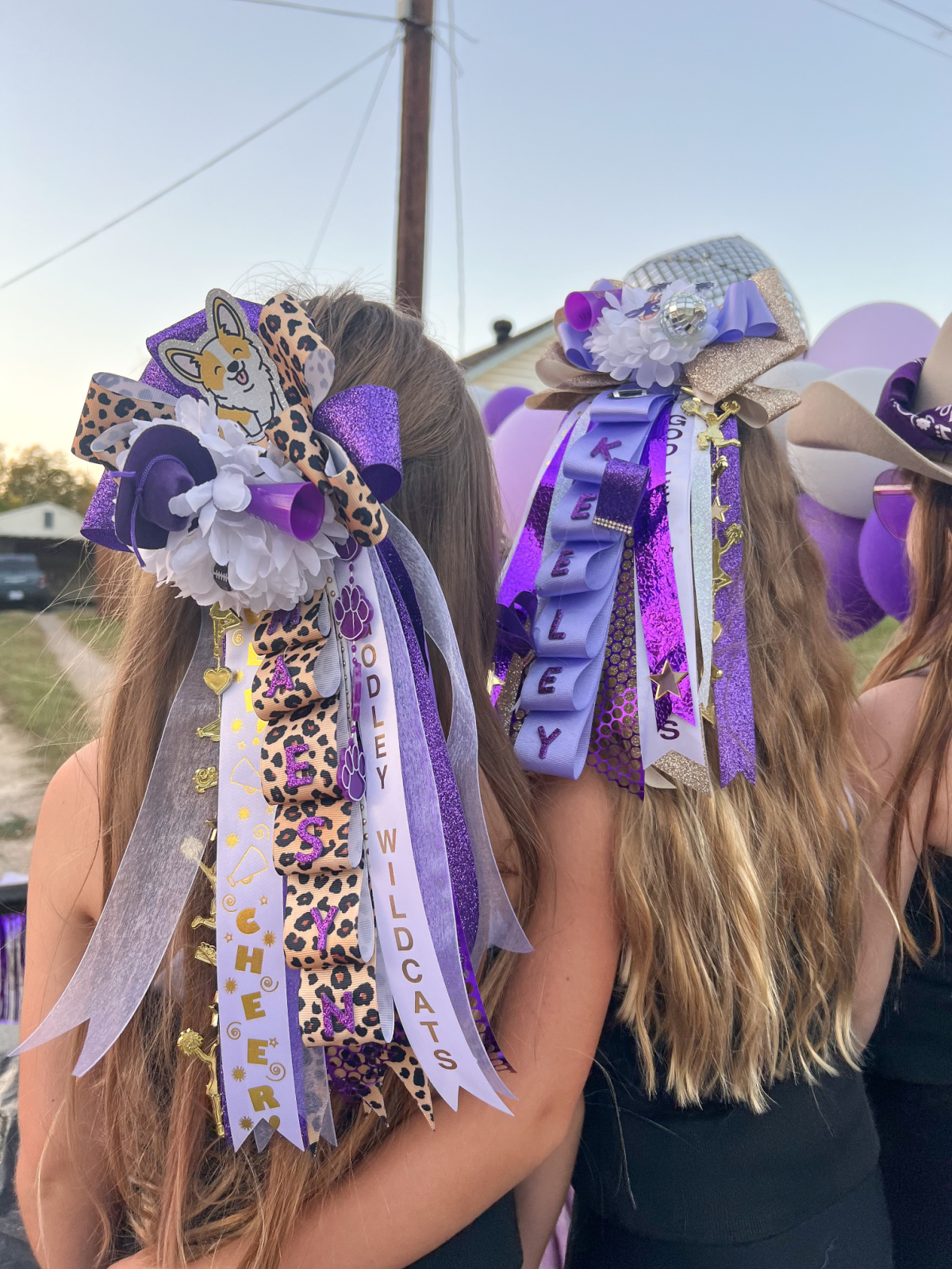 Two little girls wearing homecoming mums in their hair.