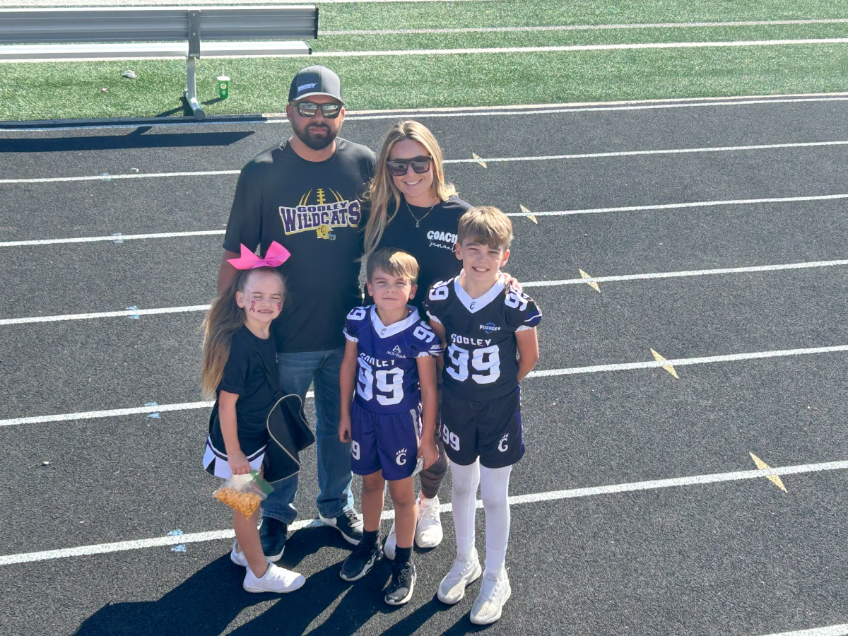 Family standing on track of high school.