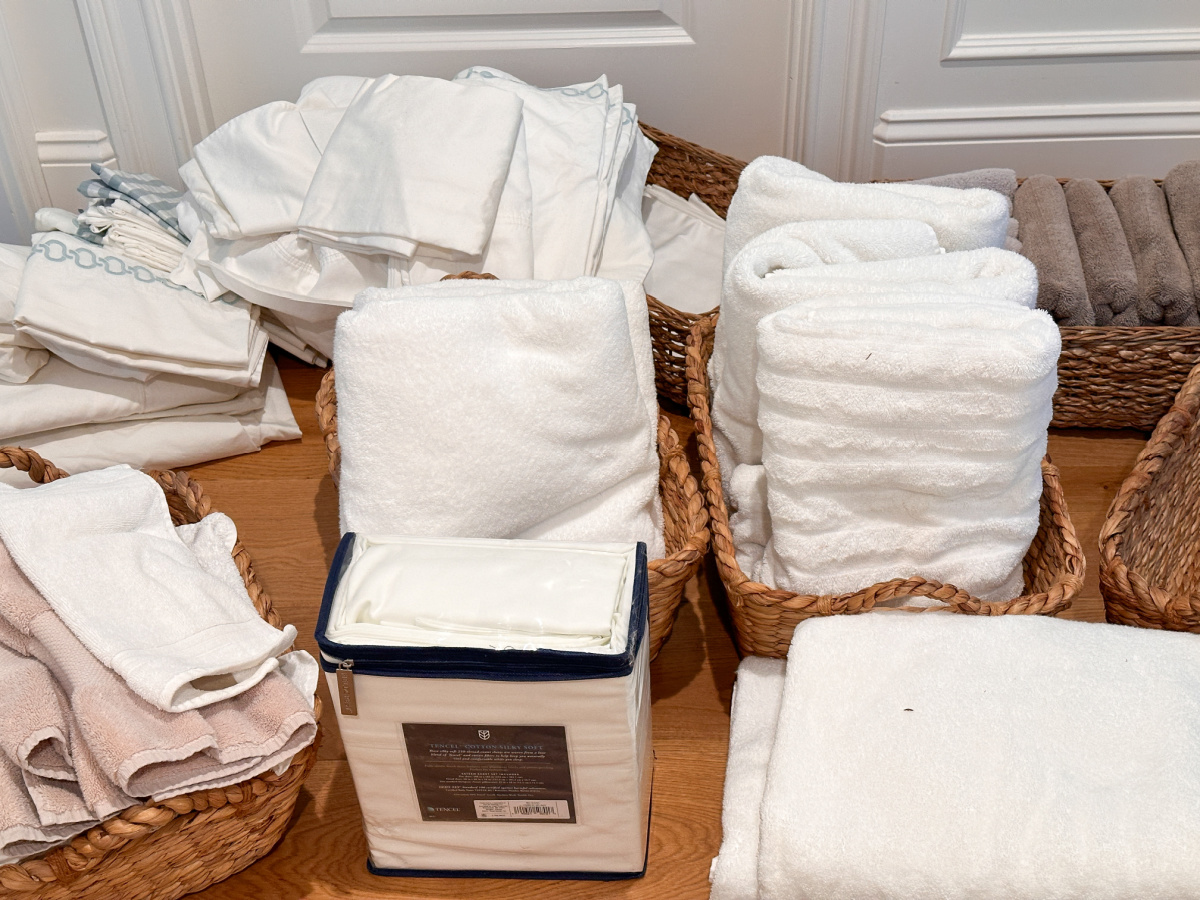 Sheets and towels on floor waiting to be organized.